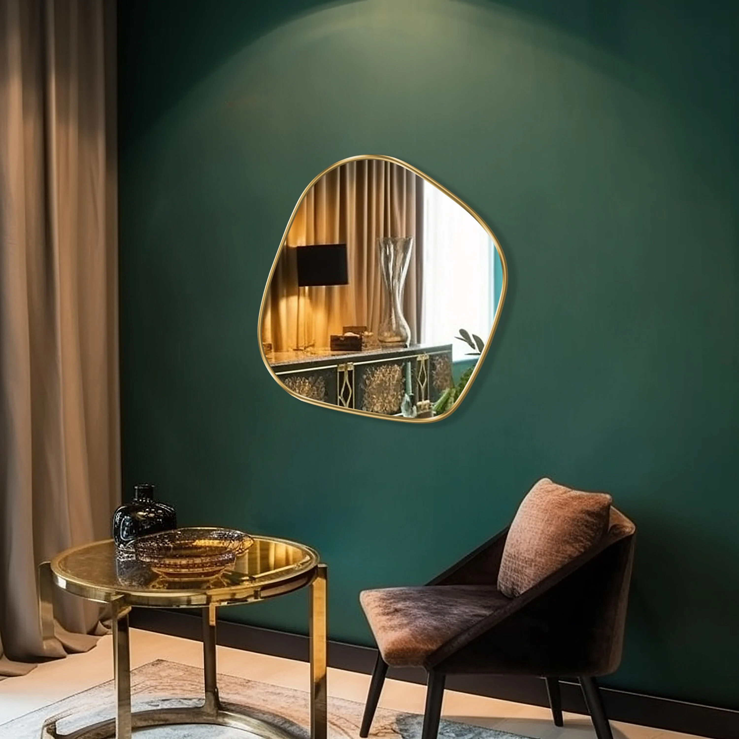 Blob shaped mirror with gold frame hung on the wall of a living room.