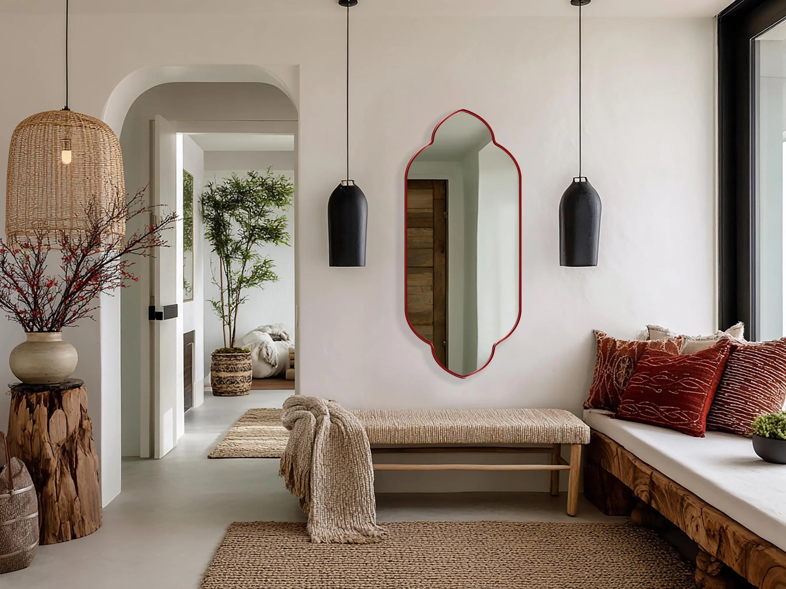 Zafira Mirror with red frame finish hung on the wall of a bohemian living room over a bench.
