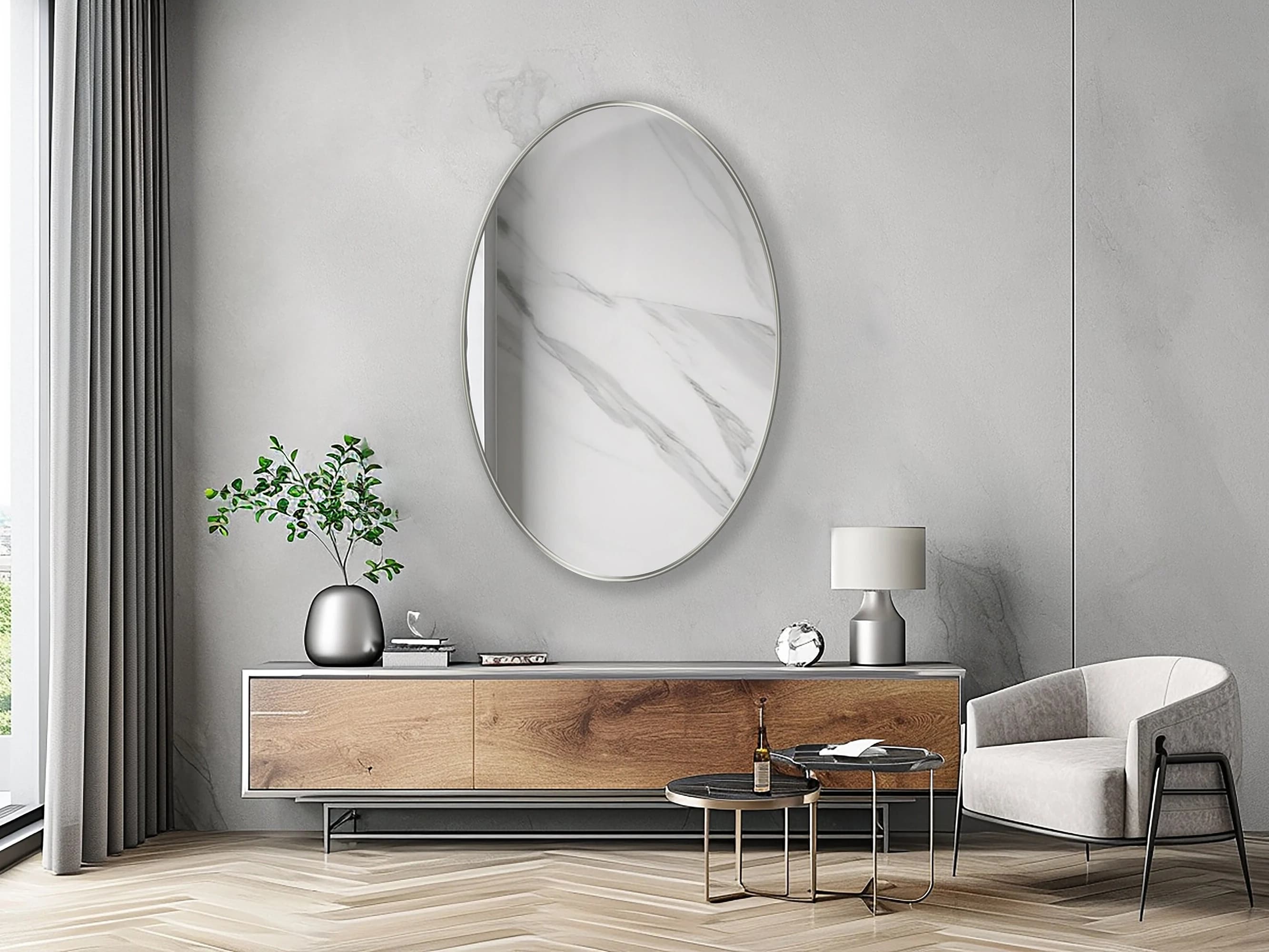 Oval Mirror with silver frame hung on the wall of a living room over a console.