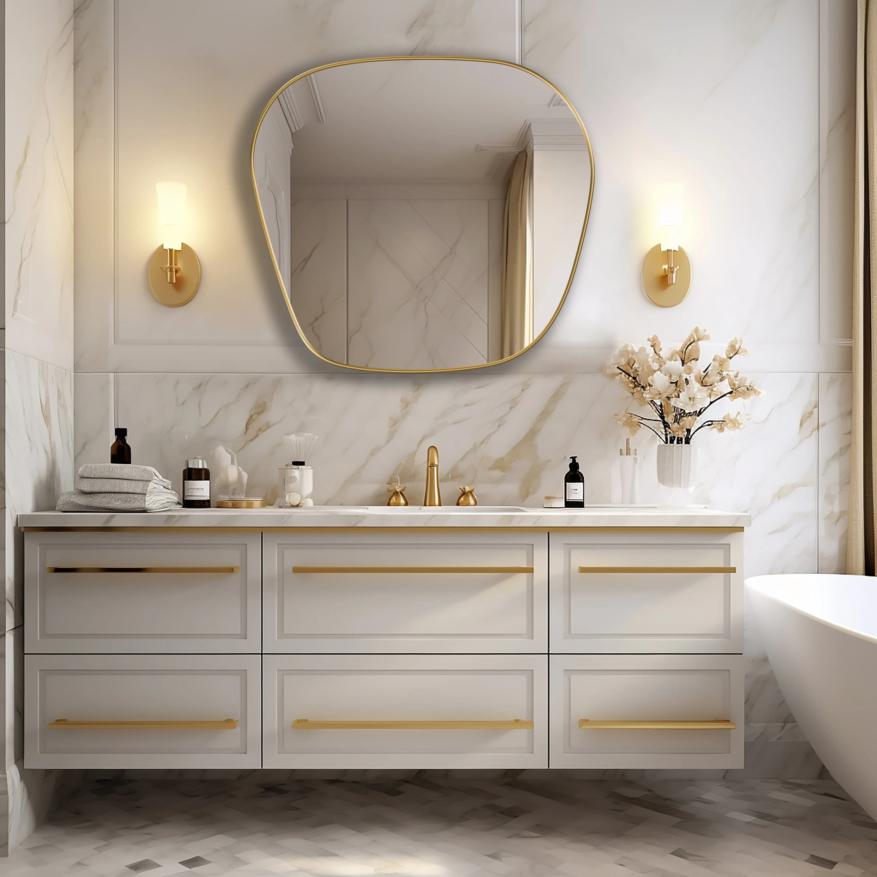 Blob mirror with gold frame finish hung on the wall of a bathroom over a vanity.