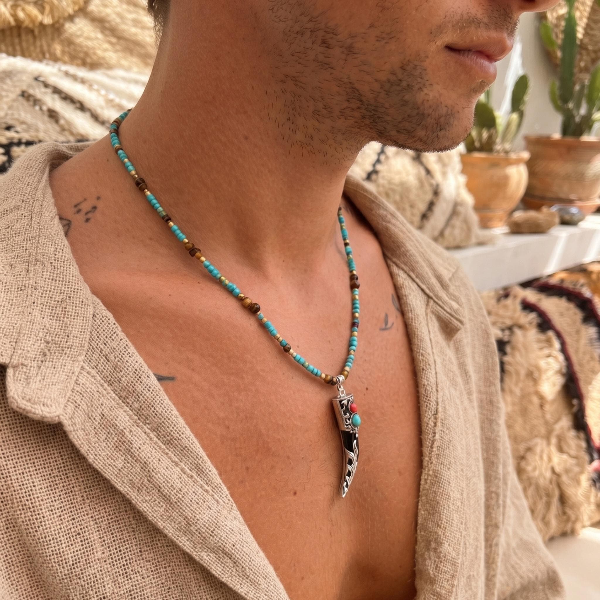 Tibetan horn pendant necklace with turquoise seed beads and golden accents, boho festival jewelry gift for him on dark background