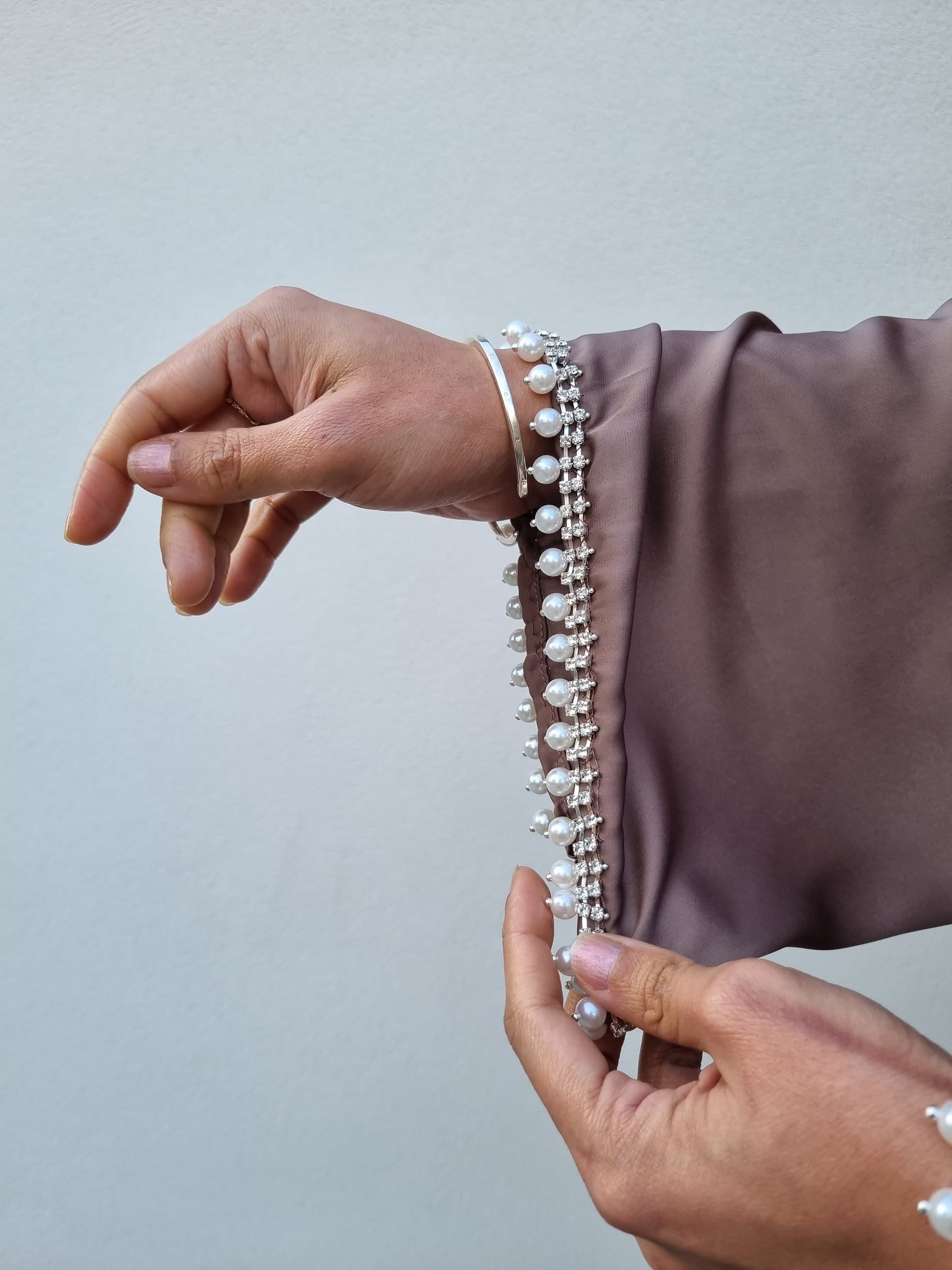 Close-up detail of the pearl and diamonds diamante on this stunning satin abaya