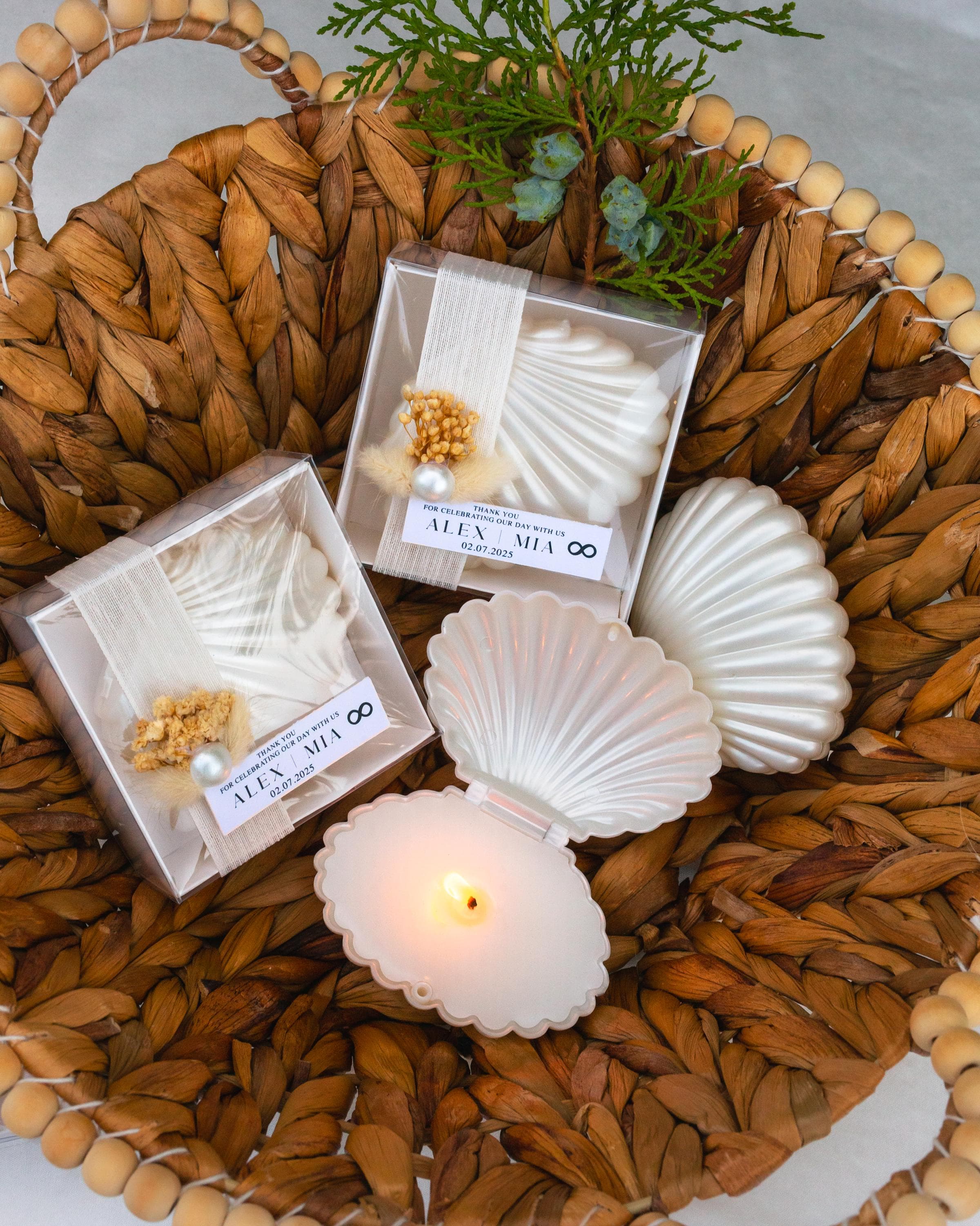 Oyster-inspired soy wax candle with pearl detail, custom wedding favor boxed with ribbon and floral decoration for seaside celebrations.