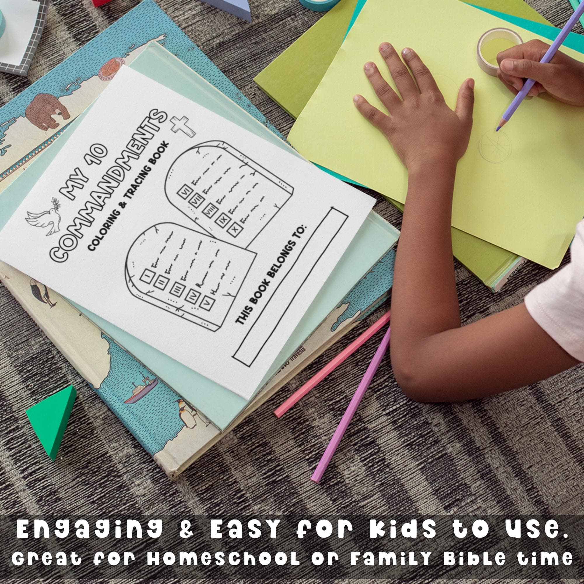 A girl siting on the carpet with colored pencils completing a Ten Commandments tracing activity as part of their Bible study at home.