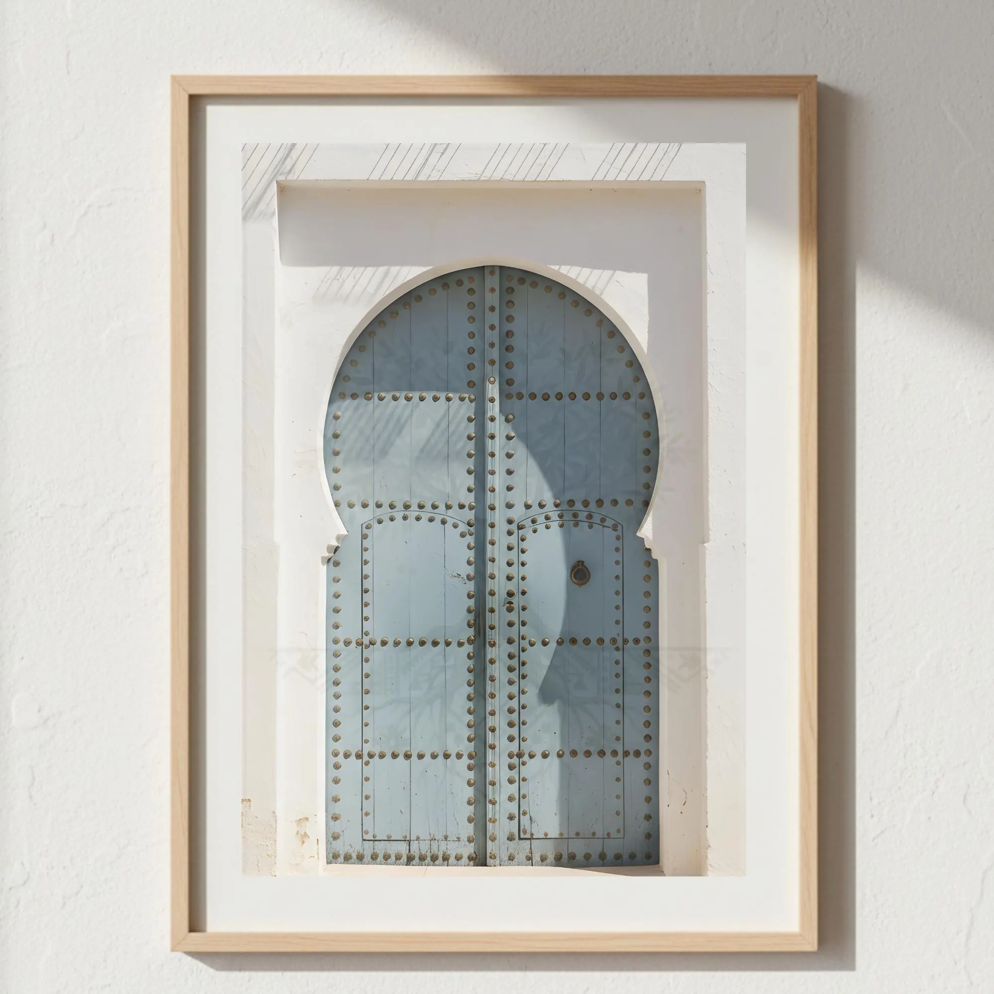 Dusty-blue Andalusian door inside a white stone frame, captured in warm sunlight with elegant textures. This calming printable art suits bedrooms, entryways, coastal homes, neutral living rooms, and minimalist Mediterranean aesthetics.