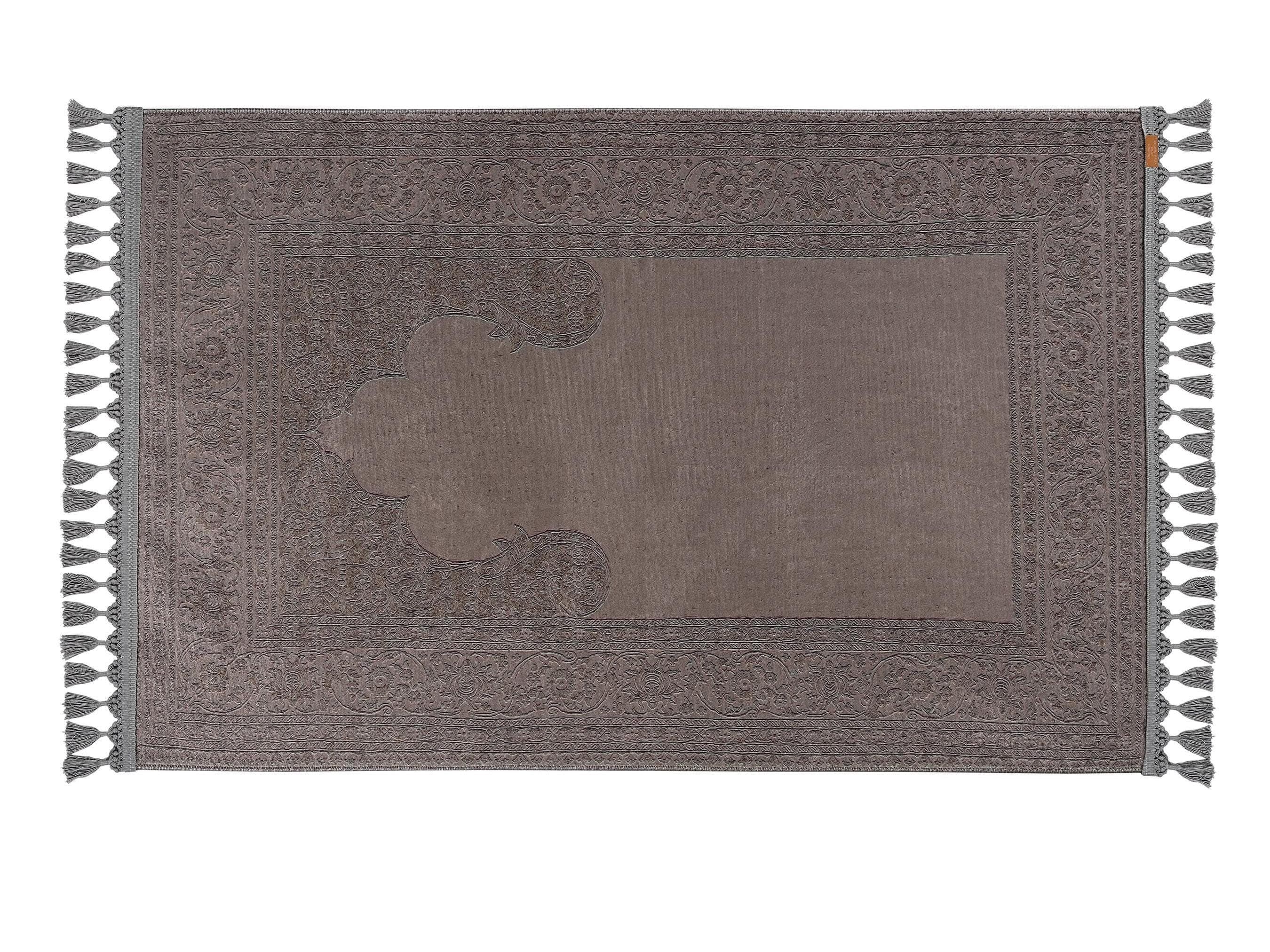 Turkish prayer rug with a grey solid mihrab design, made of soft cotton woven base with non-slip backing. Measures 80x125 cm (31.5"x49.2"), 7 mm thick, and weighs 1.738 kg. Inspired by minimalist Islamic architecture, it showcases elegant style with hand-knotted fringes. Ideal for daily prayers at home, travel, or mosque. A meaningful gift for weddings, Ramadan, Eid, or Hajj. Optional name personalization and custom sizing available.