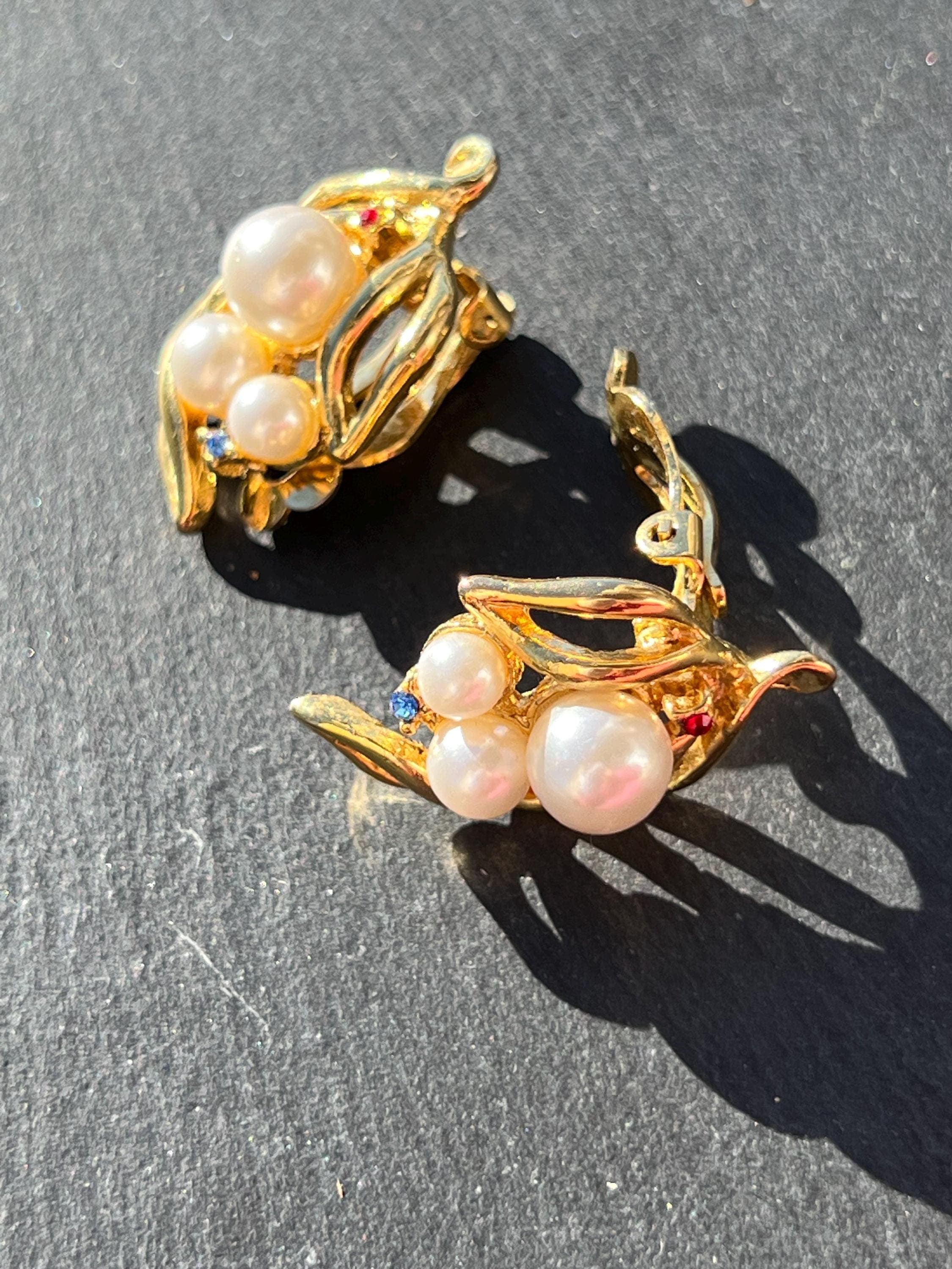 Vintage gold-tone clip-on earrings with floral design and imitation pearls, photo in the sun