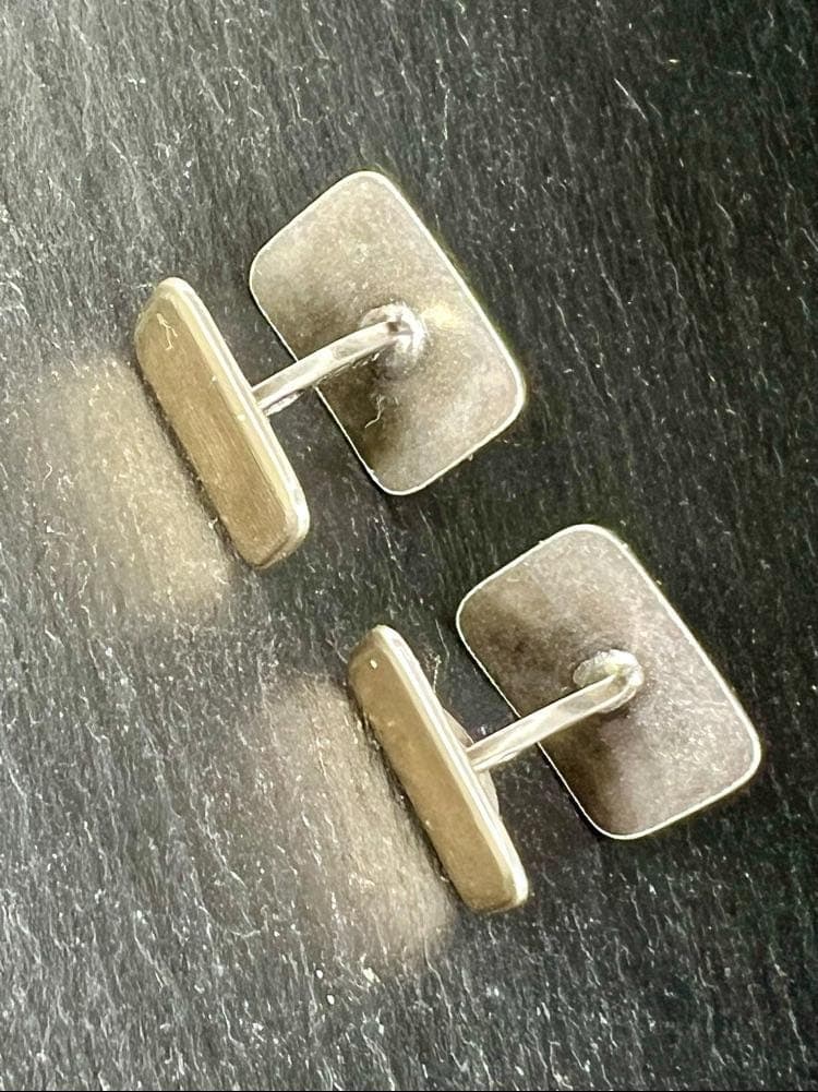 A close-up shot of a pair of rectangular vintage cufflinks. They are made of silver with a ridged gold-filled front. The back of one cufflink is visible, showing the engraved maker's mark "Rinch" and the metal stamps "835/585."