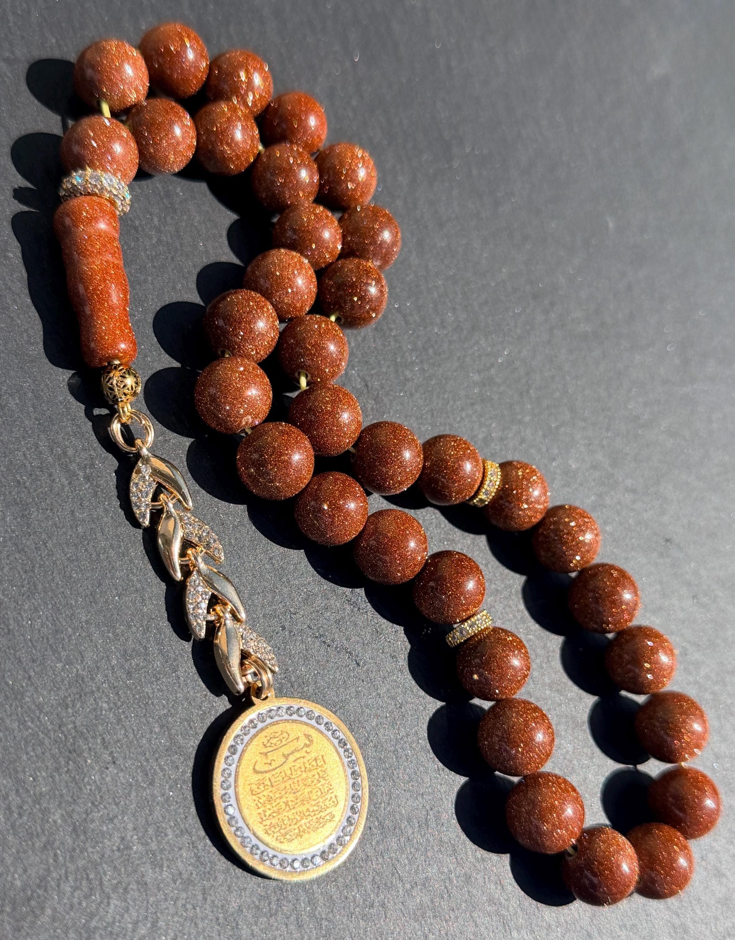 Gold Sandstone Tasbih, gold plated medal in the tassel with Yasin Quran Verses.