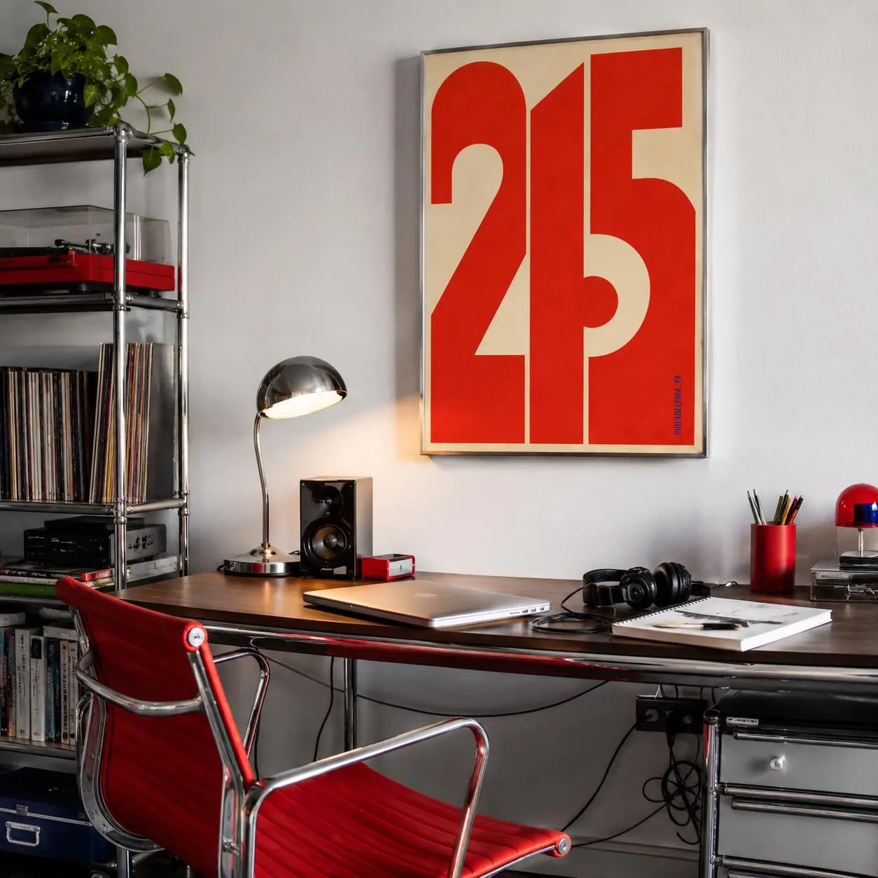 A rectangular wall poster featuring the bold red numbers 215 on a cream background, framed in a thin silver border. The design uses large, blocky typography that fills the frame, with the text 215 clearly visible in red.
