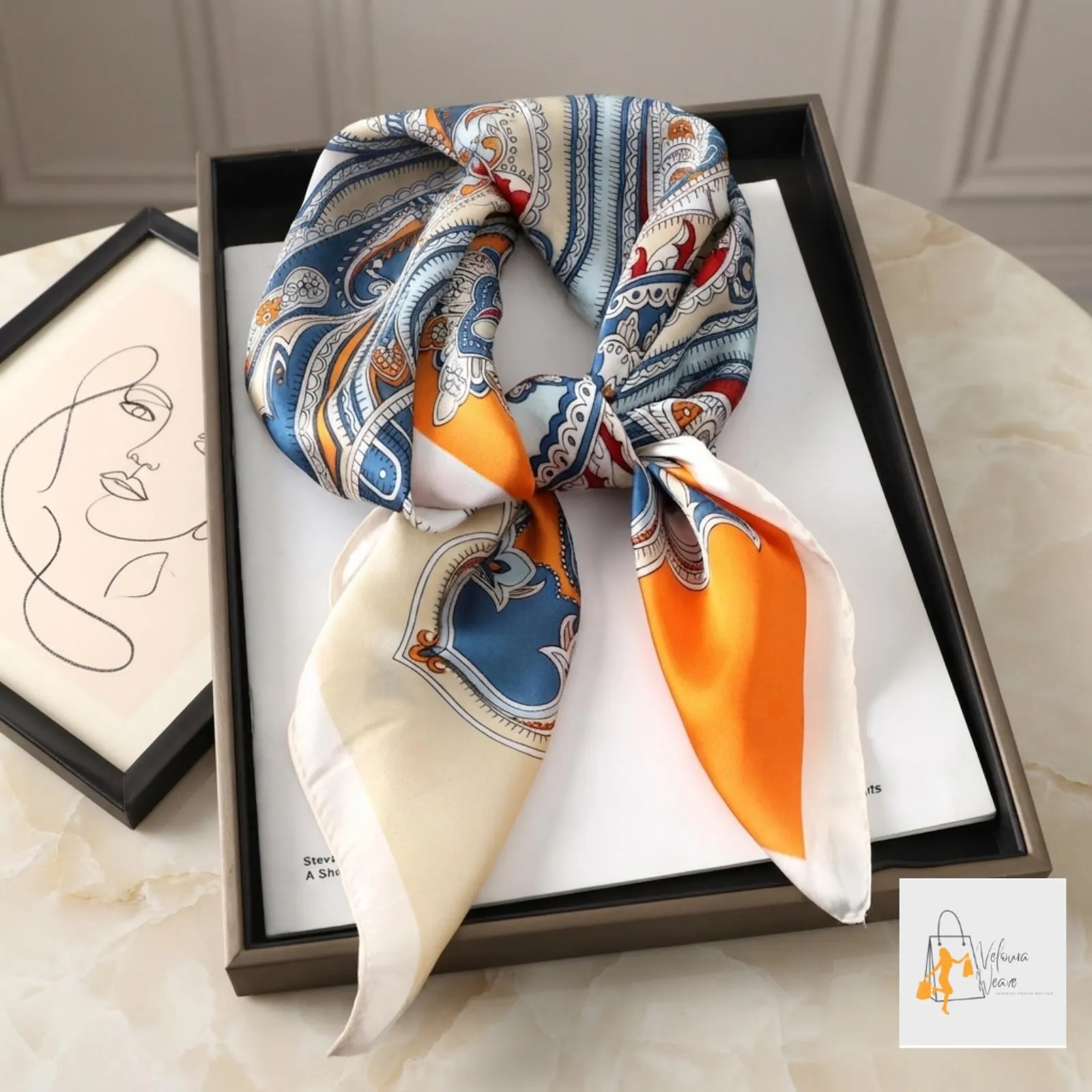 Printed satin scarf tied around a handbag handle for added style.