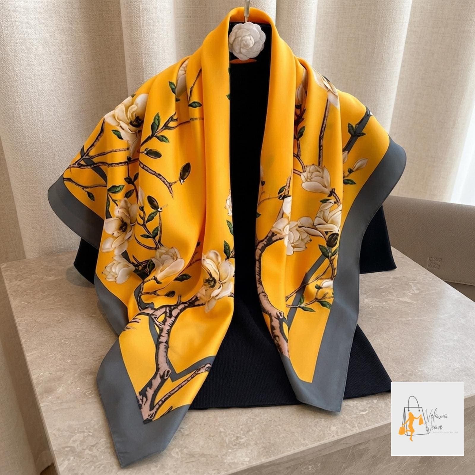 Woman wearing a large printed twill satin scarf as a stylish neck accessory.