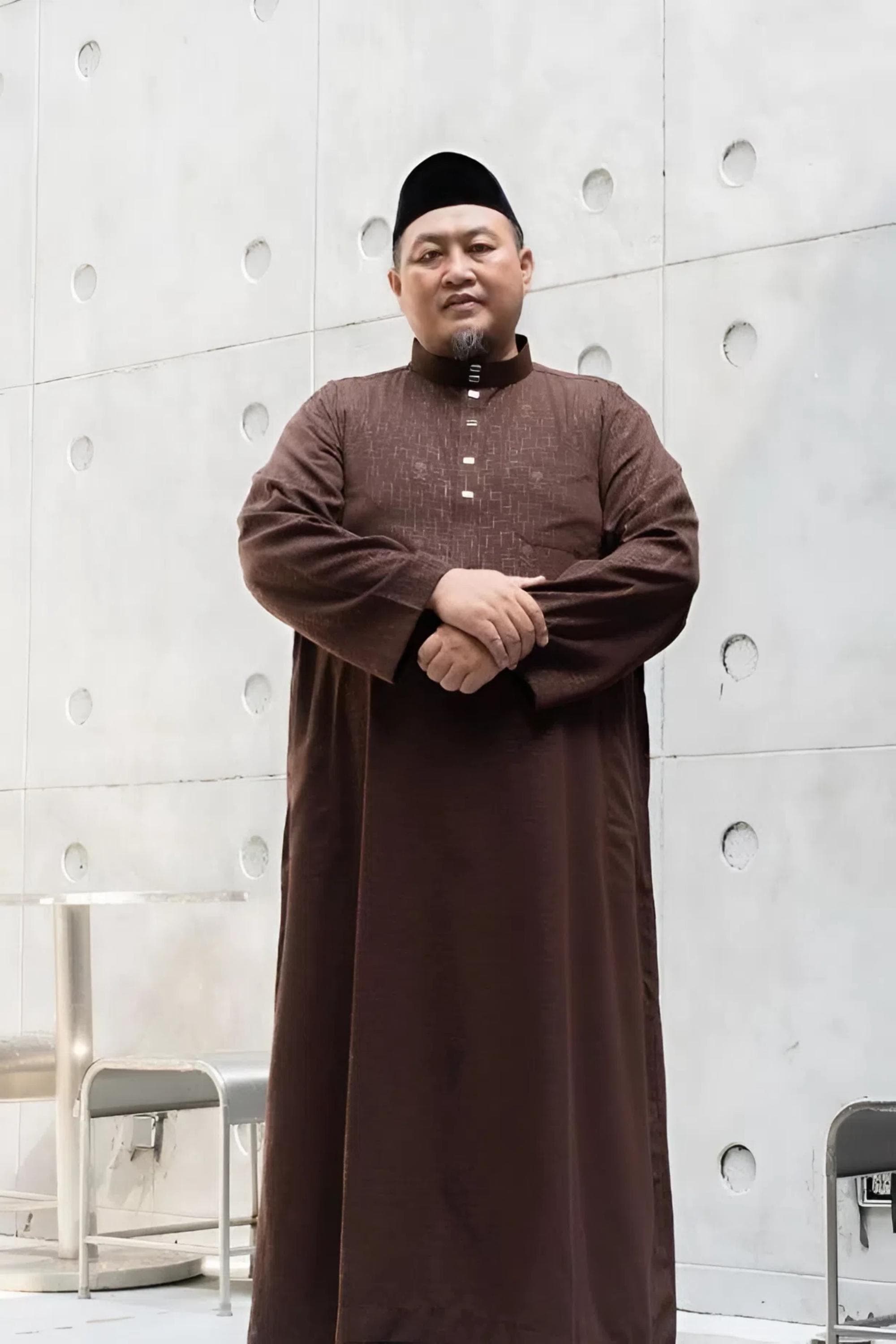 Plus size man wearing a dark gray premium embossed thobe with a stand collar and snap buttons