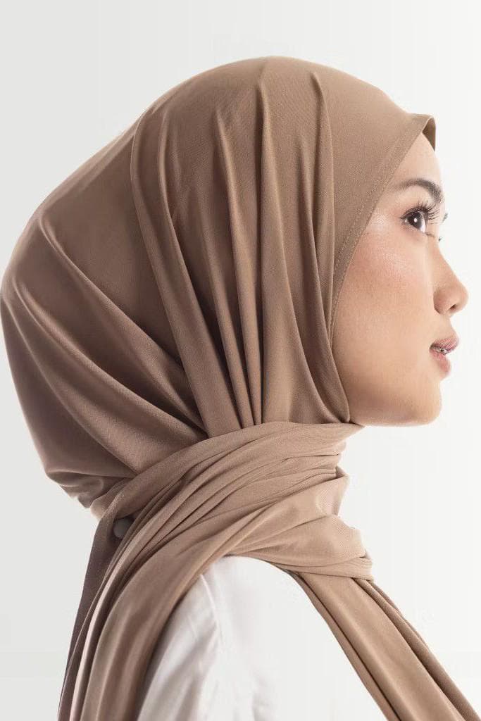 Woman wearing instant pashmina hijab in espresso brown, oval cut, made from soft wrinkle-resistant premium fabric.