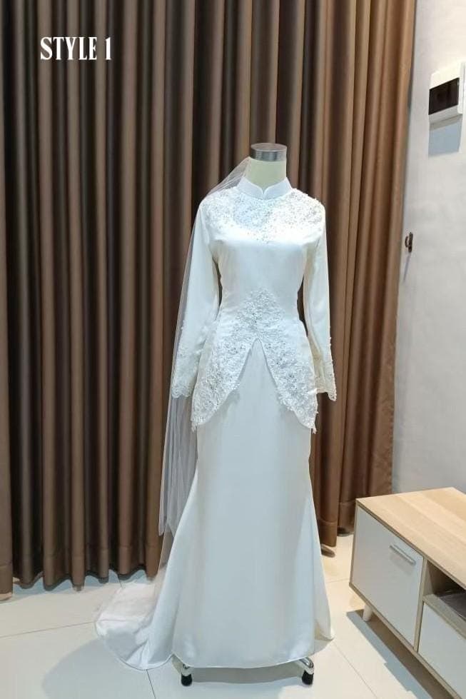 White long-sleeve formal dress with lace and bead embellishments displayed on a mannequin, paired with a matching skirt and veil.