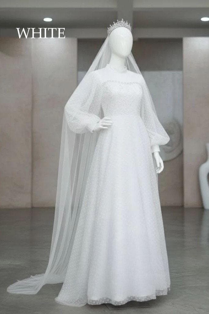 Long-sleeve velvet and dotted tulle modest wedding dress with beaded details displayed on a model