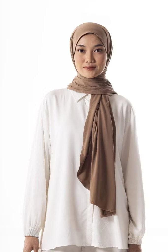 Woman wearing instant pashmina hijab in espresso brown, oval cut, made from soft wrinkle-resistant premium fabric.