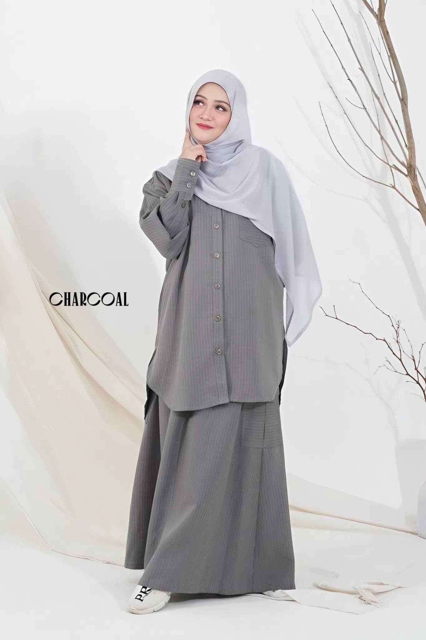 Two women wearing a striped modest two-piece set in cotton semiwool, featuring a long-sleeve top and matching skirt.