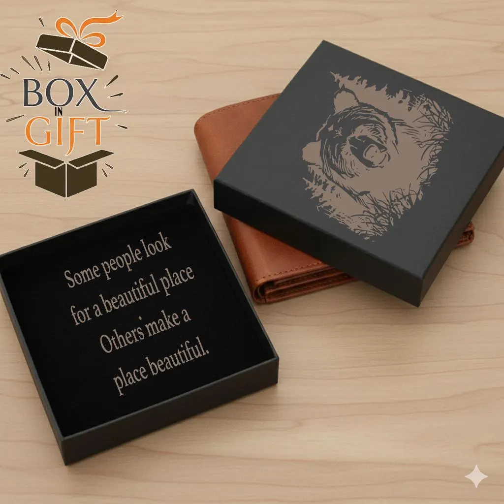 a black gift box with a bear design on it, placed on a wooden surface next to a brown wallet.