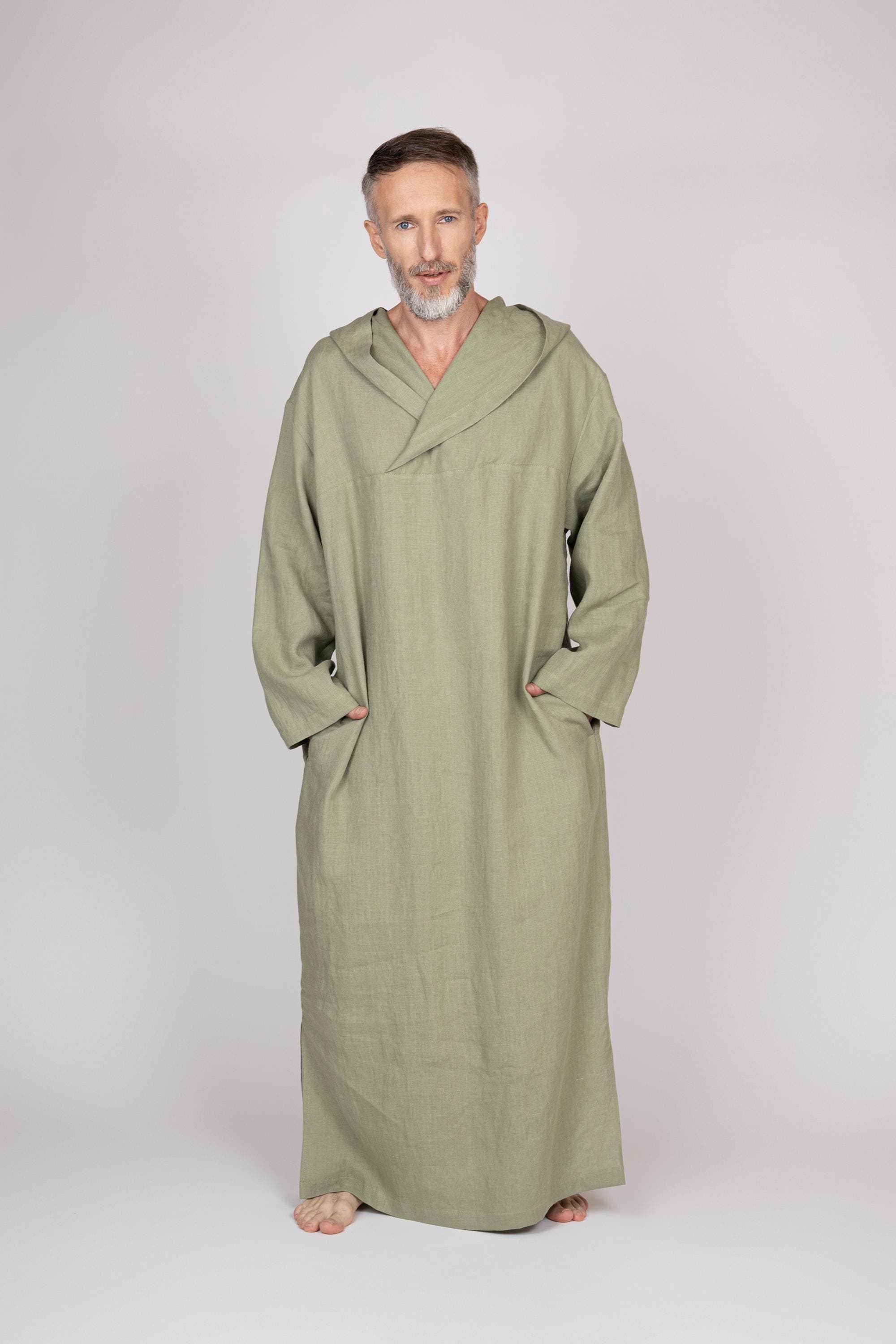 May include: A hooded robe in a light green color. The robe is made of a soft, thick fabric and has a simple design. The robe is displayed on a mannequin against a white background.