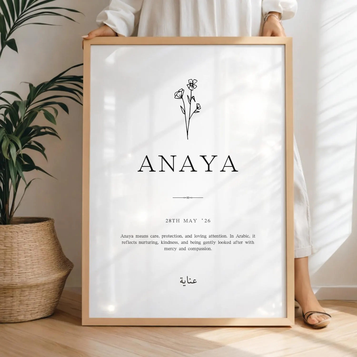 Personalized Arabic Name Print Girls – Muslim Girl Nursery Poster | Islamic Name Art | Name Meaning Islamic | Beige Islamic Print: A framed art print featuring the name "ANAYA" in a serif font, with a floral illustration. The print includes the date "28TH MAY '26" and a definition of the name. The frame is a light wood colour.