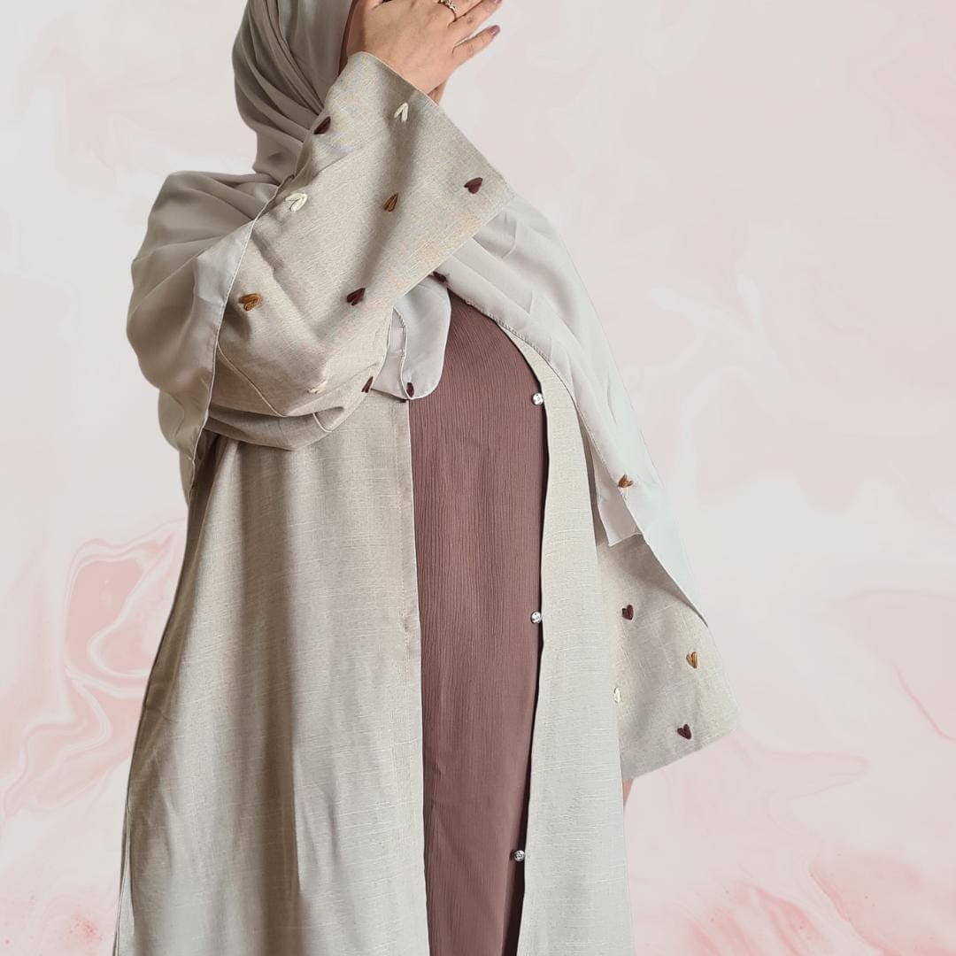 Elegant beige-grey abaya with embroidered heart designs on the sleeves, including hijab and practical pockets – ideal for everyday wear - image 4