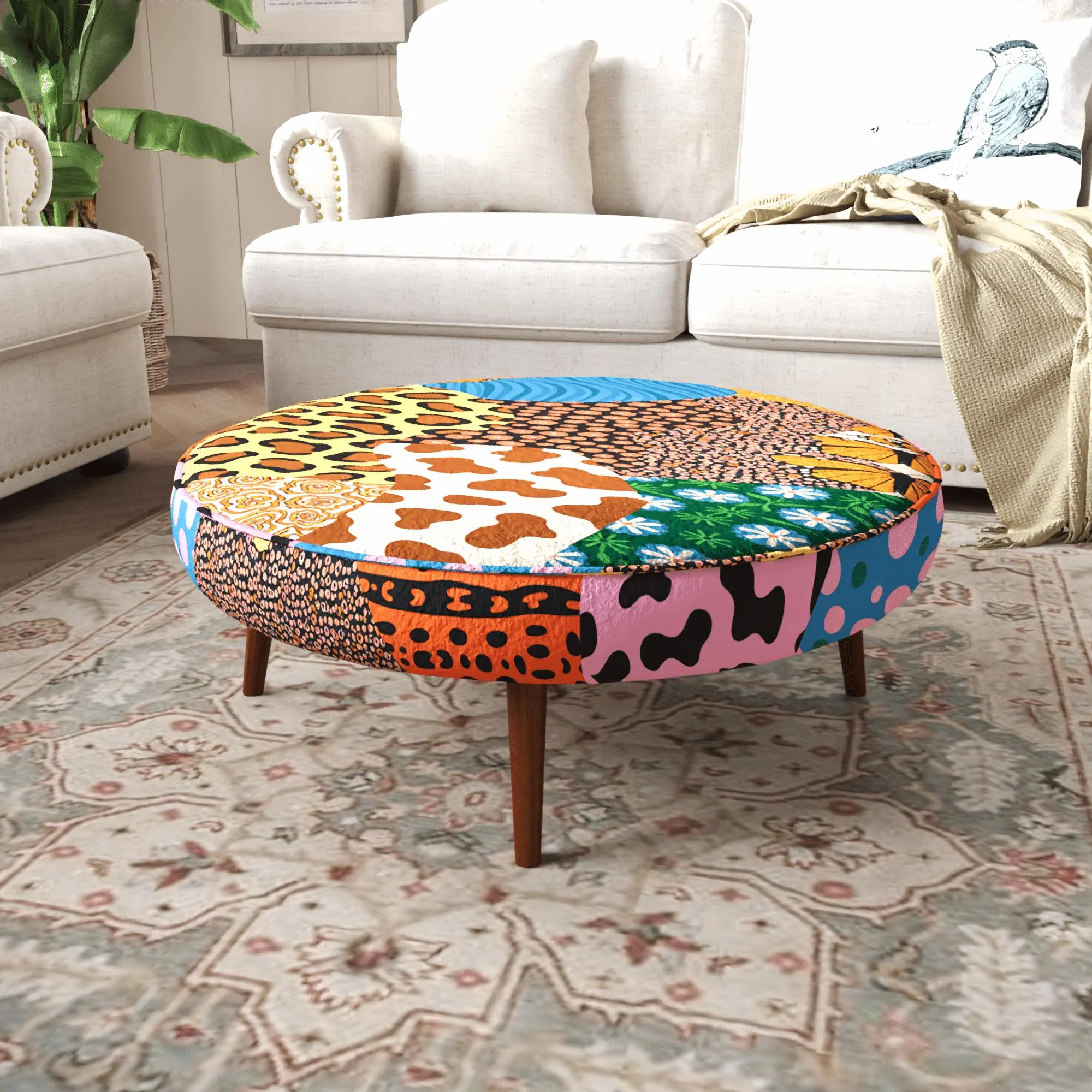 a round ottoman with a vibrant, multicolored patchwork design, placed on a patterned rug in a living room setting.