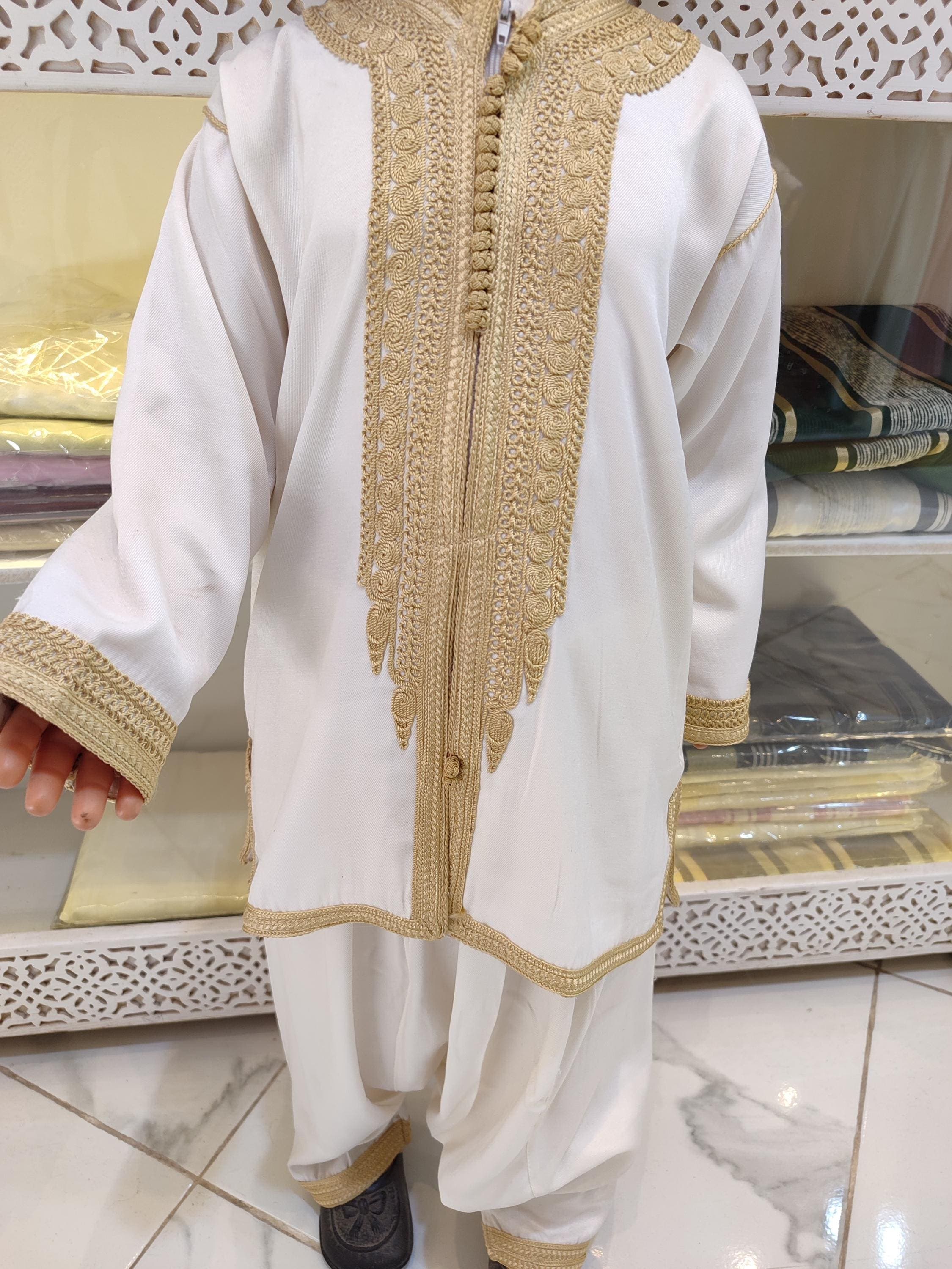 This jabador for baby boy is a heartfelt piece made for unforgettable moments like baptism, thara pak, or Eid. Designed with delicate detail and soft fabrics, it offers comfort and traditional Moroccan style. The jabador child includes matching pants and tunic, creating a full traditional outfit perfect for pictures, ceremonies, or gifts for newborn boys.