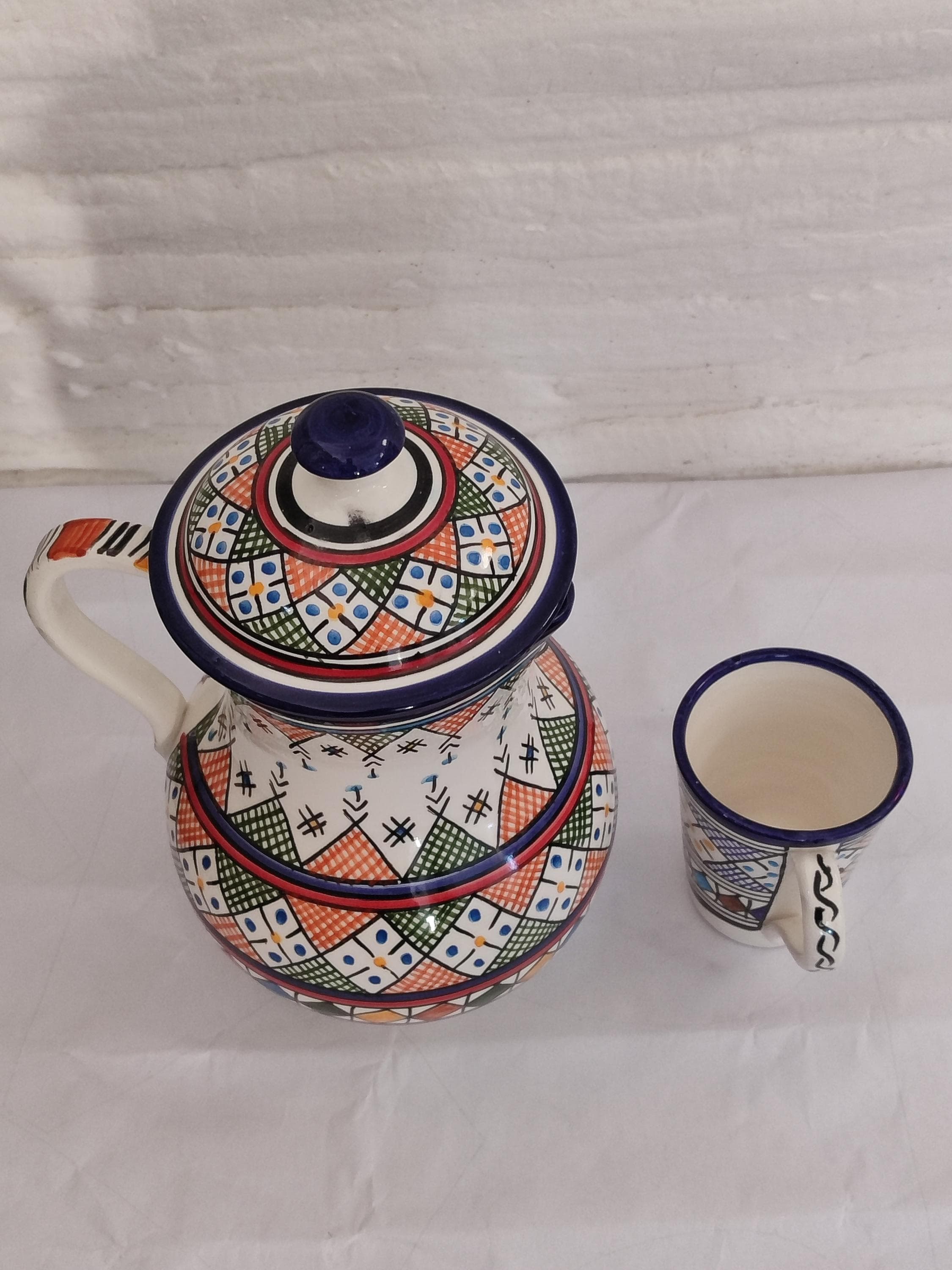 Discover the perfect blend of form and function with this handmade carafe, designed as an elegant bedside carafe. Crafted from traditional Moroccan pottery, this pitcher keeps your water cool throughout the night. The beautiful geometric patterns and rich colors transform a simple nightly ritual into a moment of luxury. As a prime example of Fez ceramics, this handcrafted ceramic piece adds a warm, artistic touch to your bedroom home decor. It’s a thoughtful