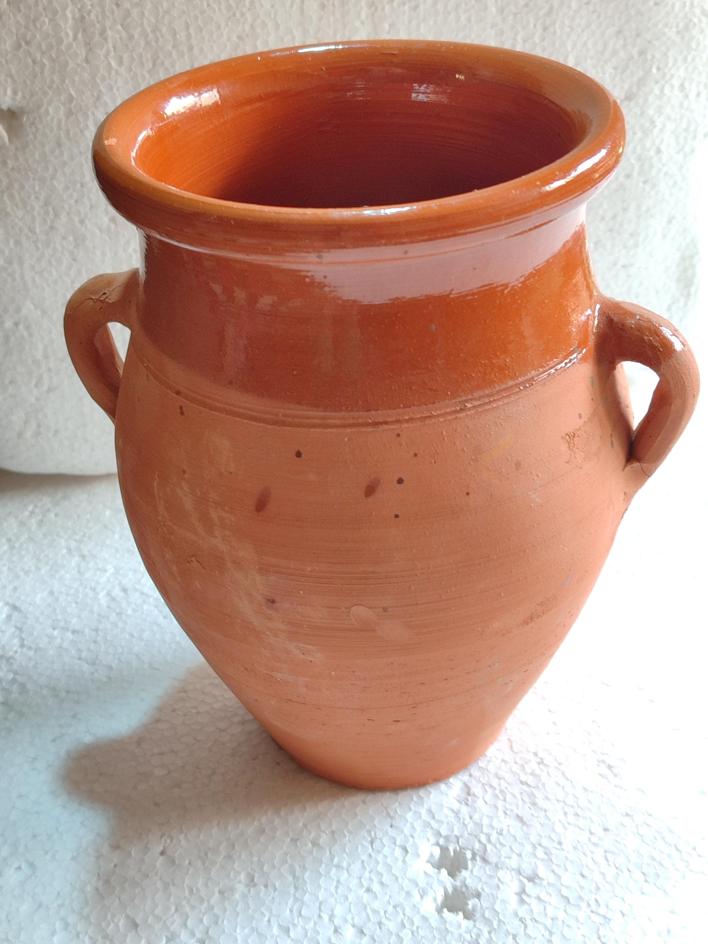 This handcrafted ceramic tangia is the perfect vessel for preparing authentic Marrakech cooking. Made from natural Moroccan clay, this Tanjia pot features a unique cylindrical design ideal for slow-cooking tender meats with aromatic spices. The thick terracotta walls retain heat beautifully, making it perfect for Moroccan stews and tagines. A must-have for lovers of North African cookware, this clay stew pot develops richer flavors with each use.  Moroccan cooking pot.