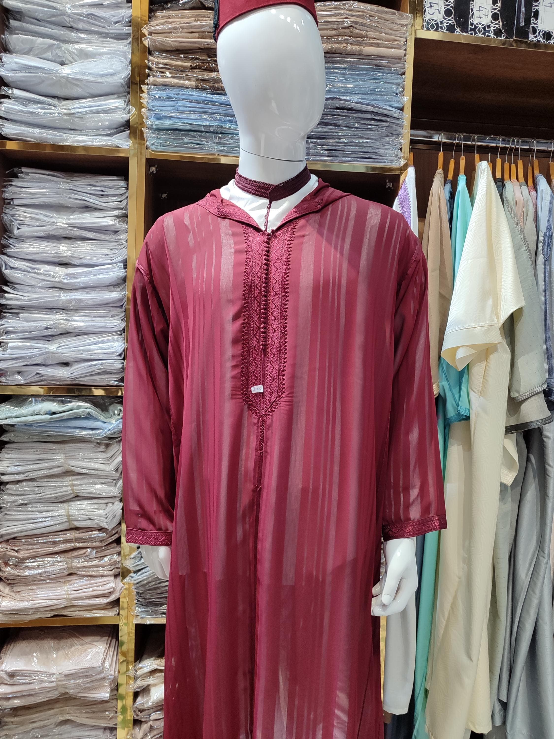 Embrace understated elegance with this creamy thobe, a stunning example of modern Moroccan gandoura for men. The neutral tone and clean lines offer a versatile look, perfect as a wedding kaftan for guests, a sophisticated Eid outfit, or formal gatherings. This Kandoura features minimalistic yet classic gandoura embroidery, showcasing the artistry of Moroccan clothing. It’s an excellent gift for husband or any man seeking a refined and versatile addition to his muslim dresses men collection