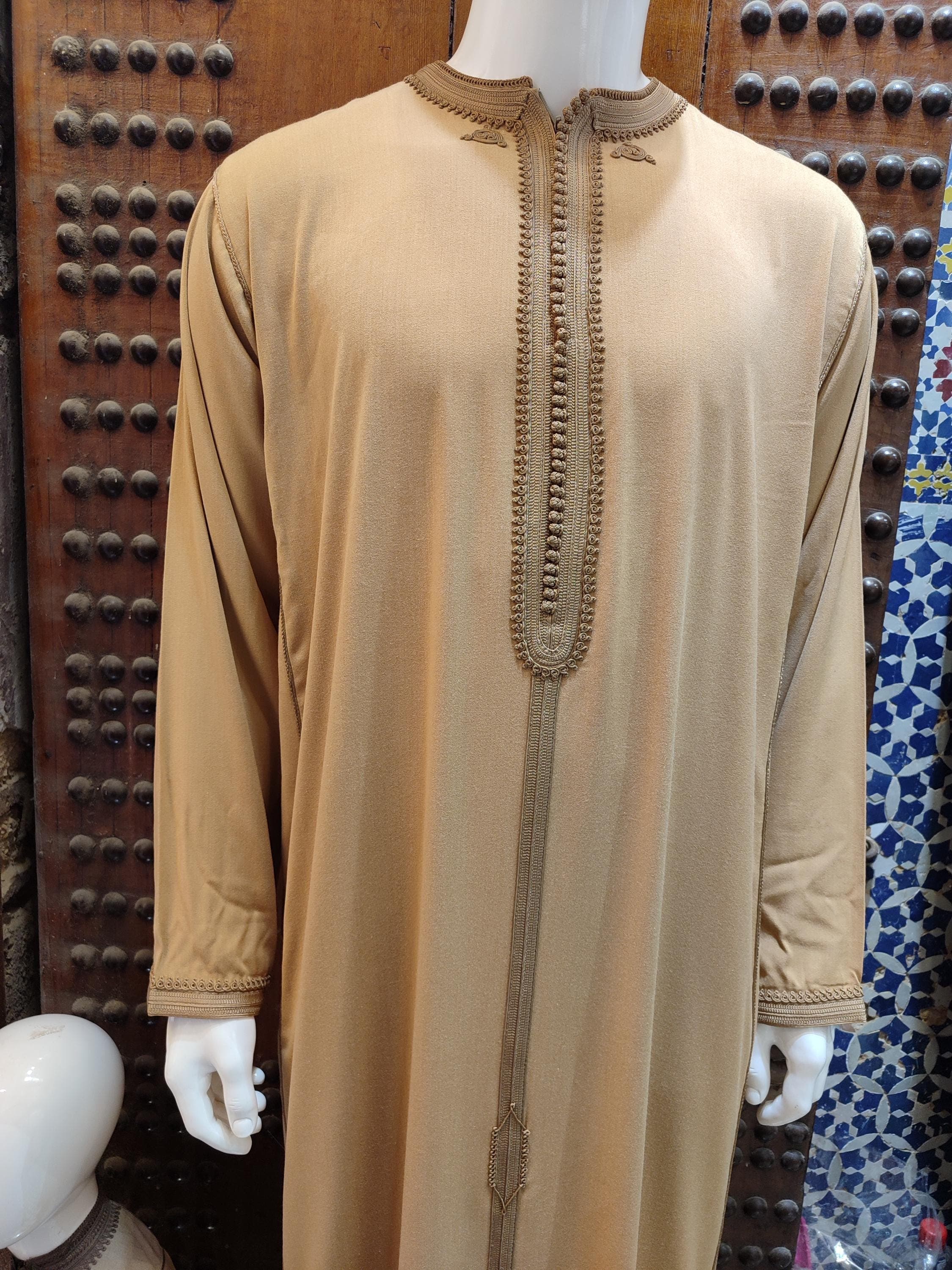 Experience ultimate sophistication with this hooded thobe for men, featuring luxurious gold embroidery and premium fabric. This Moroccan djellaba is ideal for wedding ceremonies and special occasions, blending traditional design with modern comfort. The attached hood adds a distinctive touch to this handmade masterpiece, making it perfect for nikkah caftan events or formal gatherings. A timeless addition to any man's formal wardrobe.
