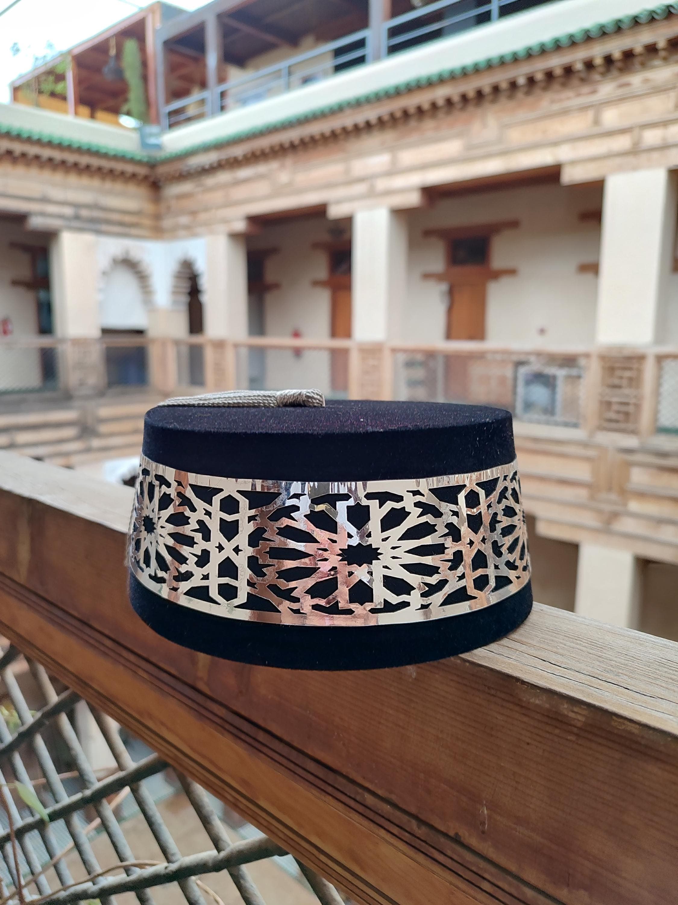 Discover the elegance of this fully customizable Moroccan Tarboosh Hat. This handmade masterpiece is made from soft black velvet and comes with a detachable silk tassel, allowing you to choose a color that matches your djellaba marocaine or personal style. As a central piece of Moroccan traditional attire, this Fez hat is perfect for special occasions, cultural events, or as a unique gift. Its authentic design is reminiscent of historical items, offering both beauty and cultural significance.