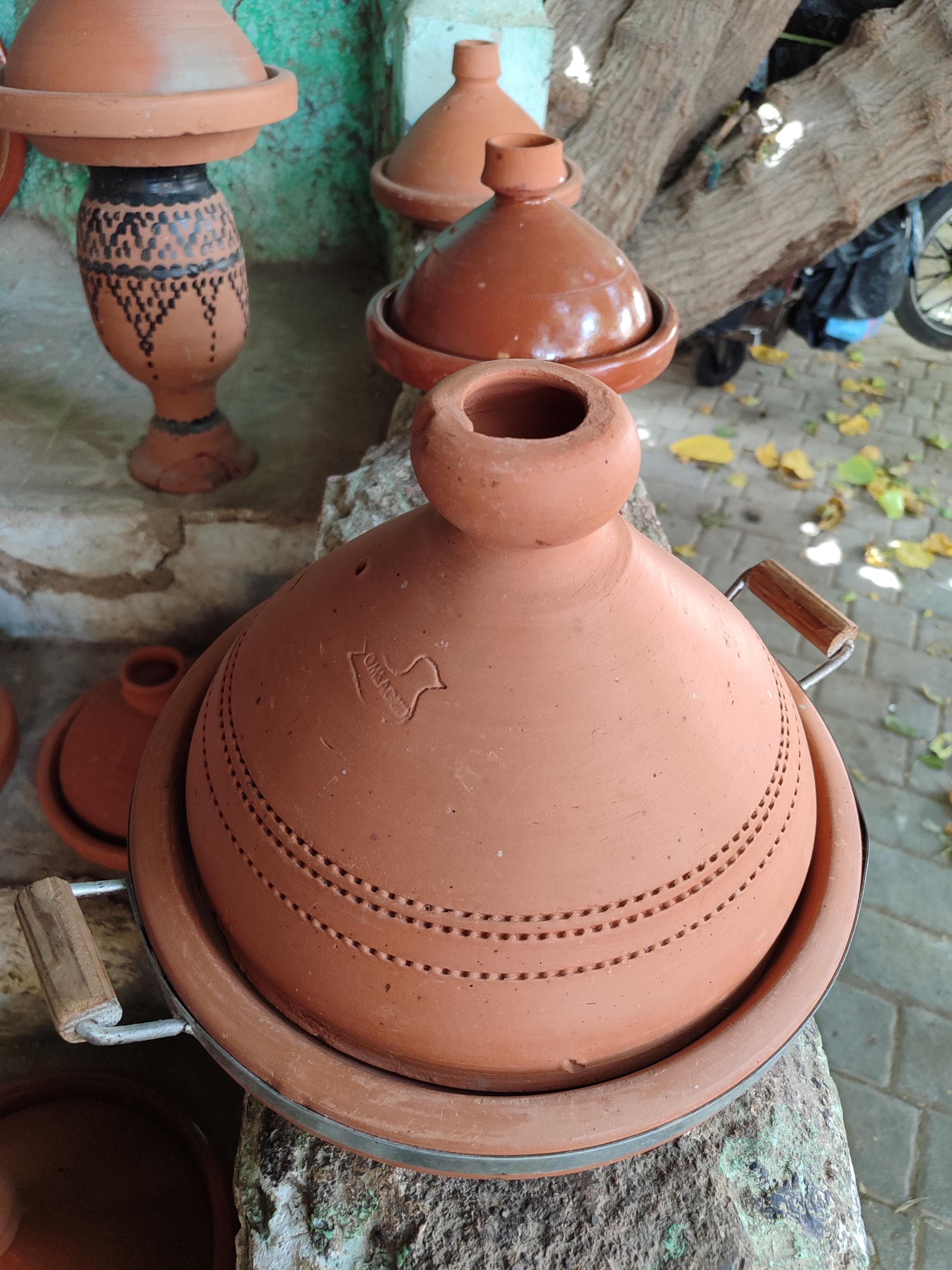 Each handmade clay tagine is uniquely crafted by Moroccan artisans using centuries-old techniques. This premium terracotta tagine features a glazed exterior with traditional designs and an unglazed interior for optimal slow cooking performance. The thick clay walls distribute heat evenly, perfect for preparing Moroccan tajine dishes with rich, developed flavors. Works beautifully on stovetops, in ovens, or as a decorative tagine display. authentic Moroccan cookware and ethnic cooking traditions.