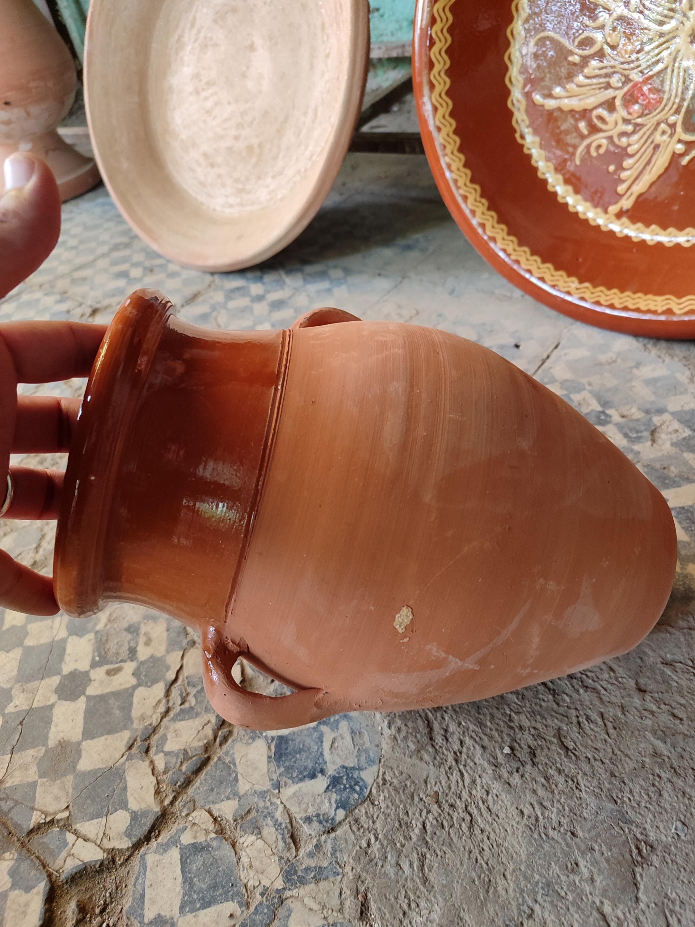 This authentic Moroccan tangia represents centuries-old cooking traditions from Marrakech. Made from sturdy ceramic, this cooking pot is designed for the unique preparation of tanjia - where meat becomes incredibly tender through slow baking in ashes. The terracotta material provides excellent heat retention while the wide base accommodates generous portions. Each handmade piece shows slight variations, proof of its artisanal Moroccan ceramic heritage.