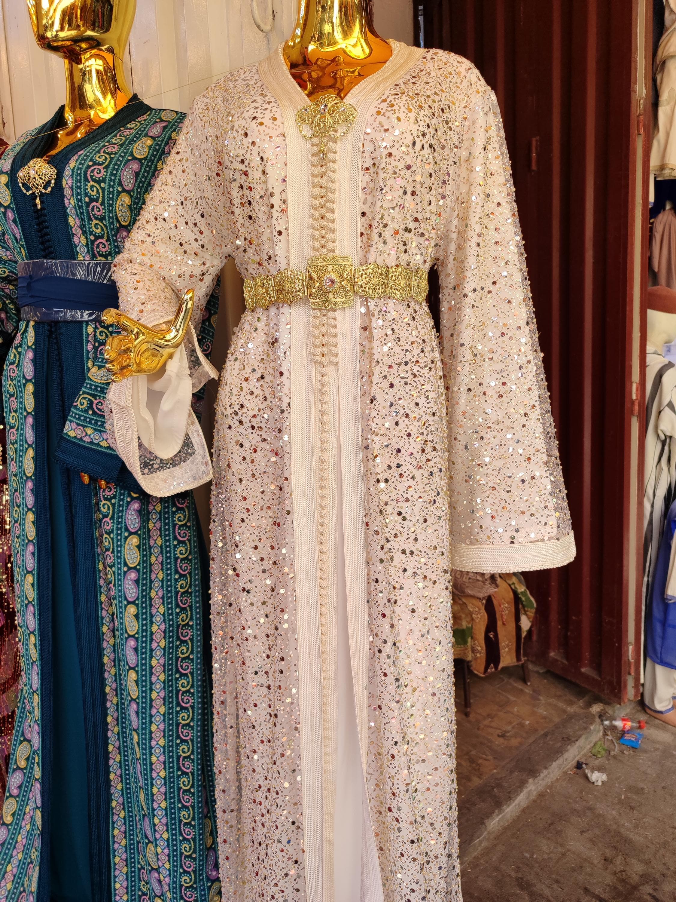 Our stunning Moroccan takchita set redefines bridal kaftan dresses with its luxurious white fabric and ornate detailing. This Arabic kuftan features a two-piece design with a fitted underdress and flowing overdress, creating a regal silhouette perfect for Muslim wedding dress occasions. The hand-embroidered patterns and delicate beadwork make this nikah caftan a masterpiece of Moroccan craftsmanship. Whether for your nikah ceremony or henna night,
