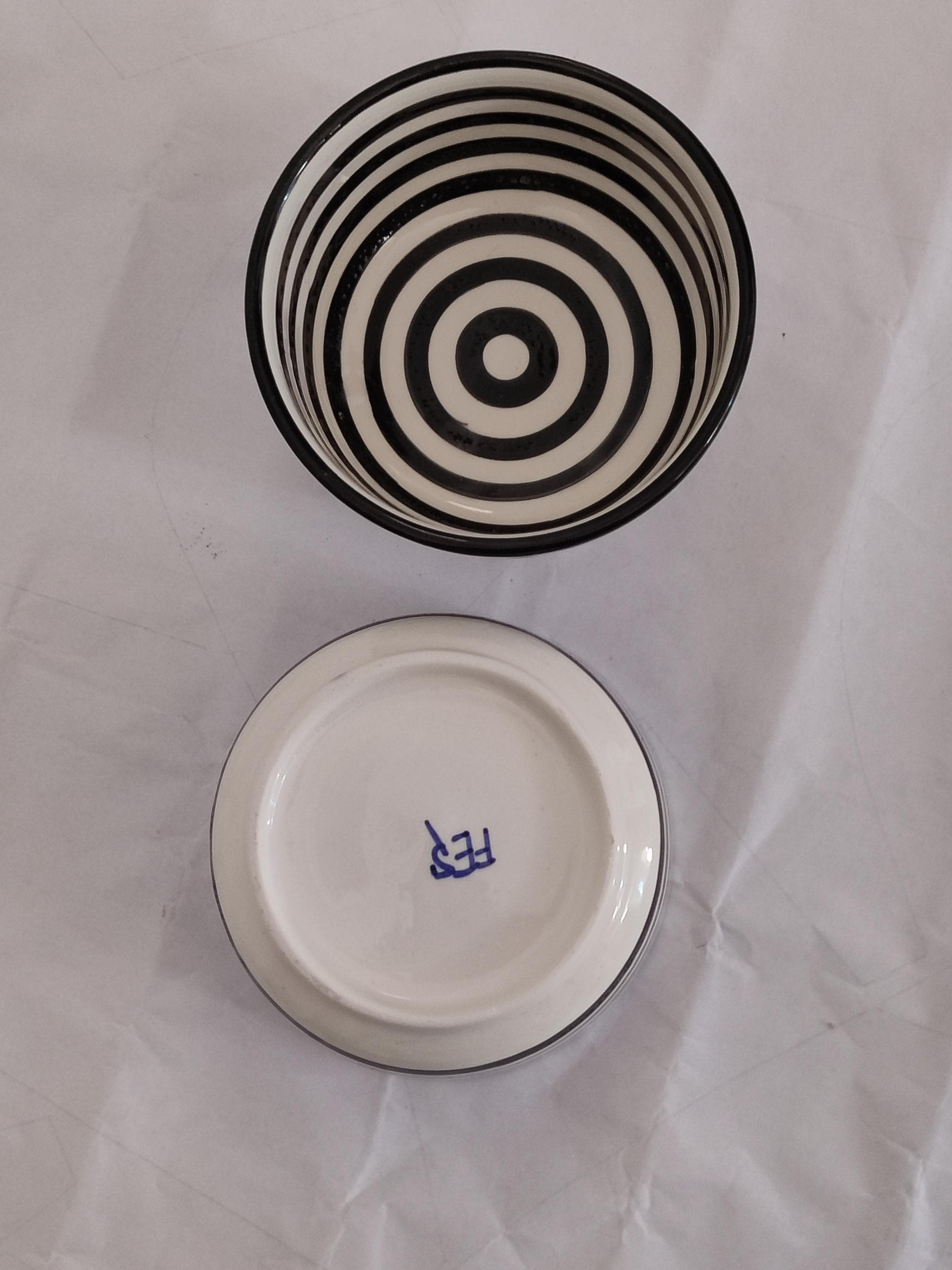 Embrace the charm of Moroccan pottery with this set of handmade ceramic serving bowls. The black and white striped motif adds a touch of boho elegance to your dining experience. Crafted by skilled artisans, these wheel-thrown bowls are both lightweight and durable, suitable for everyday use or special gatherings. Use them as popcorn bowls, prep bowls, or centerpiece bowls to elevate your table setting. Their minimalist design blends seamlessly with various interior styles,