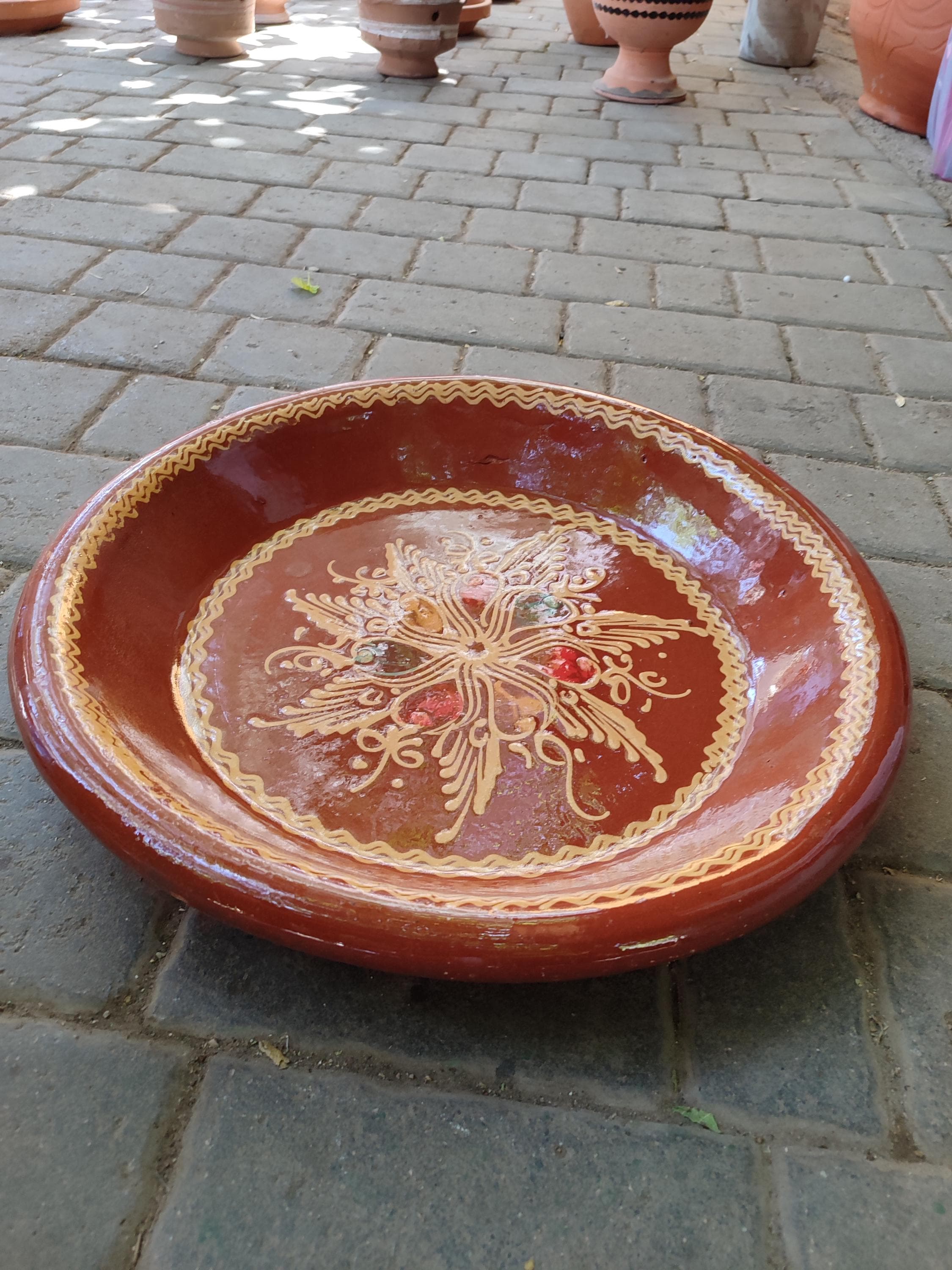 Impress your guests with this magnificent Moroccan serving plate. This 35cm Kesriya is the ultimate statement piece for entertaining, designed to serve 8 people with elegance and authenticity. Its large, flat surface is ideal for presenting couscous, mezze, or a grand cheese board. The beautiful terracotta material and antique finish make it a versatile Moroccan dish that doubles as stunning home decor. Pair it with a clay tajine for a complete, cohesive tablescape that celebrates the art