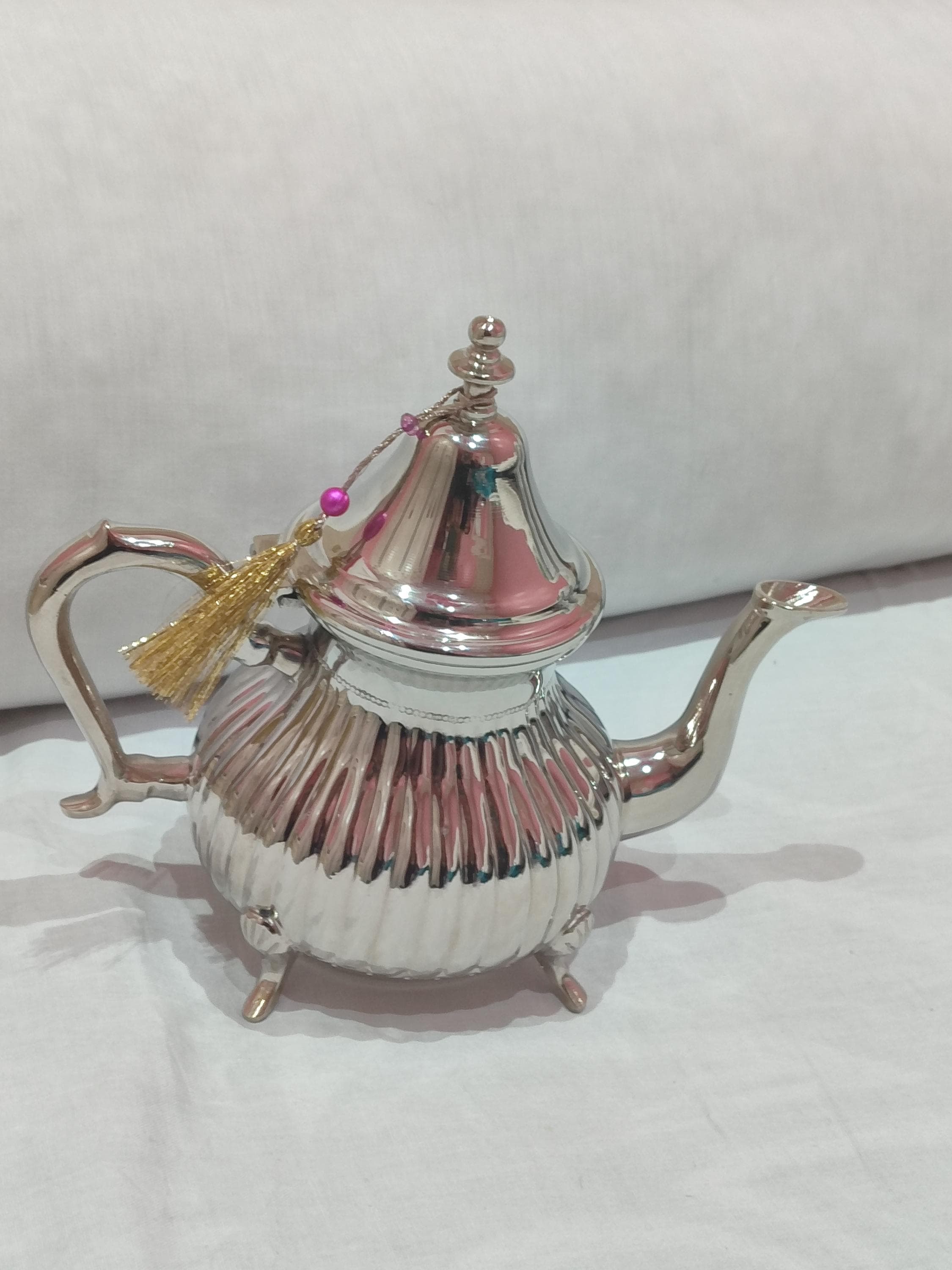 Complete your tea service with this premium Moroccan teapot set, featuring a main teapot and matching tea glasses. This handcrafted teapot Marrakech showcases exceptional Berber teapot craftsmanship with detailed filigree work and hammered silver brass finish. Designed specifically for the Moroccan mint tea ritual, the set includes all elements for an authentic tea ceremony. The stainless lining ensures easy cleaning and maintenance. As both functional teapot Morocco ware and beautiful decor,