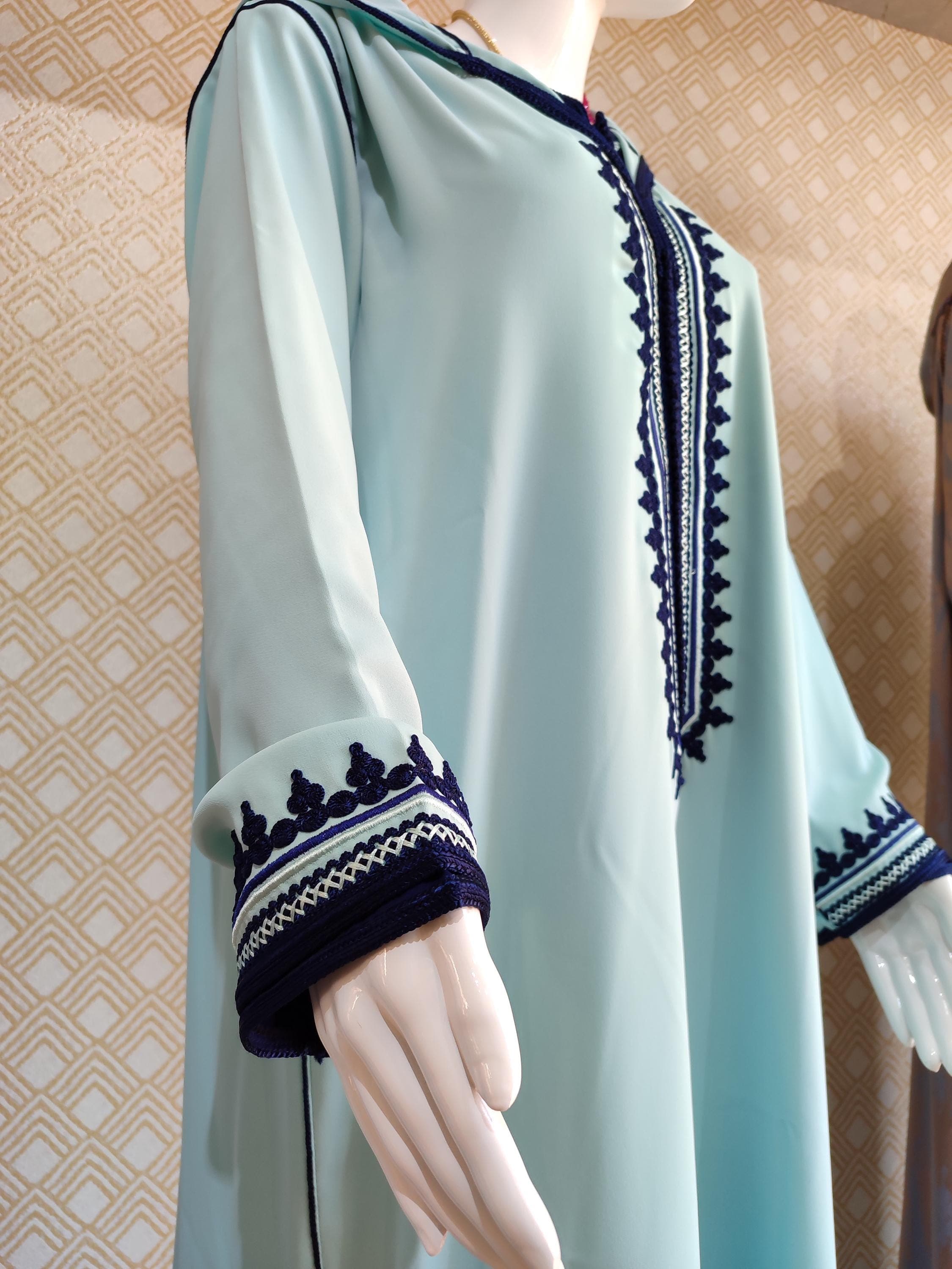 Our jellaba for women is made from premium natural fabrics that feel cool and breathable. This Traditional Jellaba has a weight similar to a light cotton bedsheet, with a subtle crispness that softens with wear. The Jellaba Morocco features underarm panels that allow for comfortable movement without restriction. The embroidered jellaba sections have a slightly raised texture that creates a pleasing tactile contrast against the smooth main fabric.
