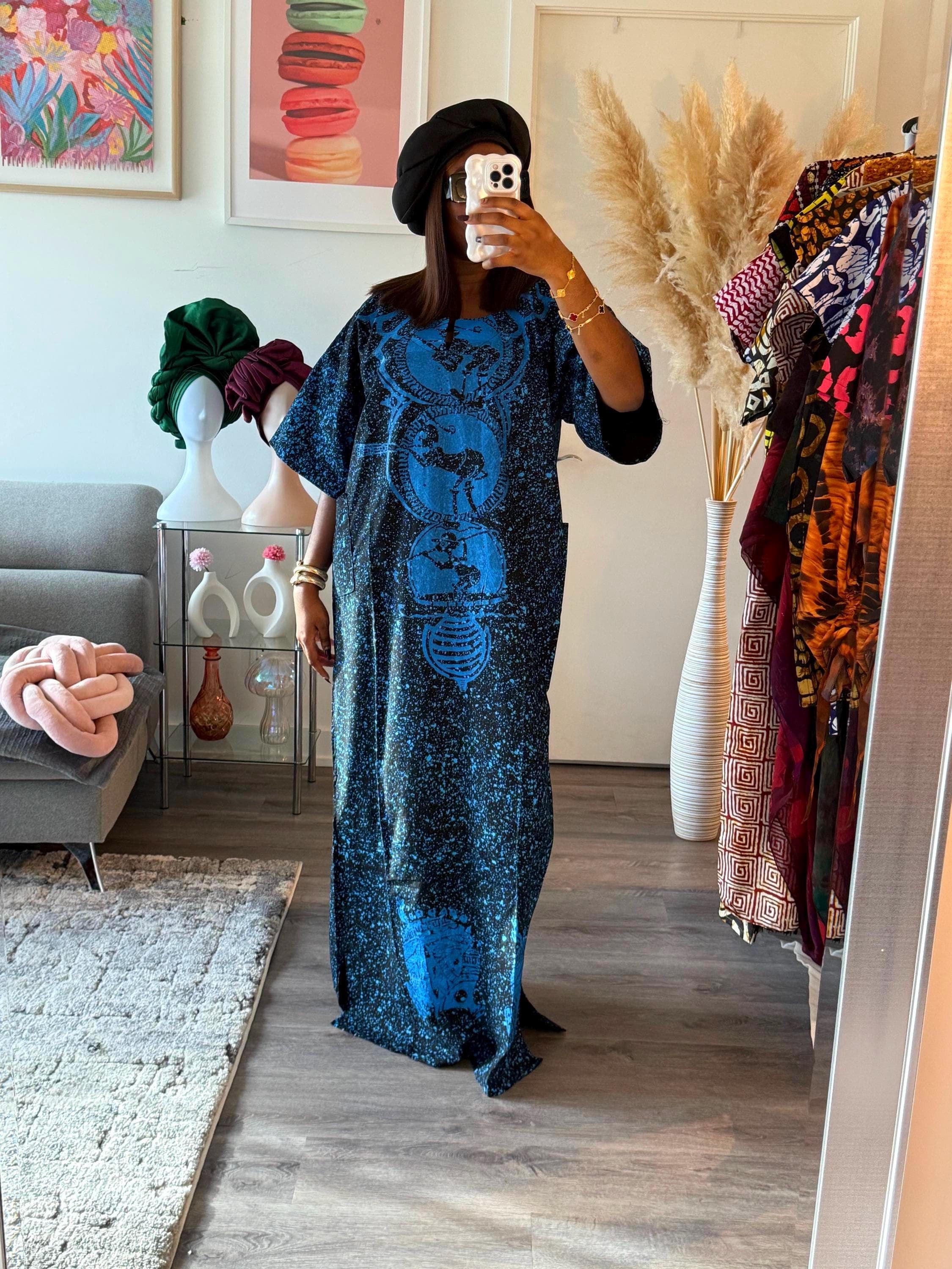 A long, black and blue maxi dress with a blue and black print. The dress has a round neckline and a loose fit. The print features a repeating pattern of circles and stars.