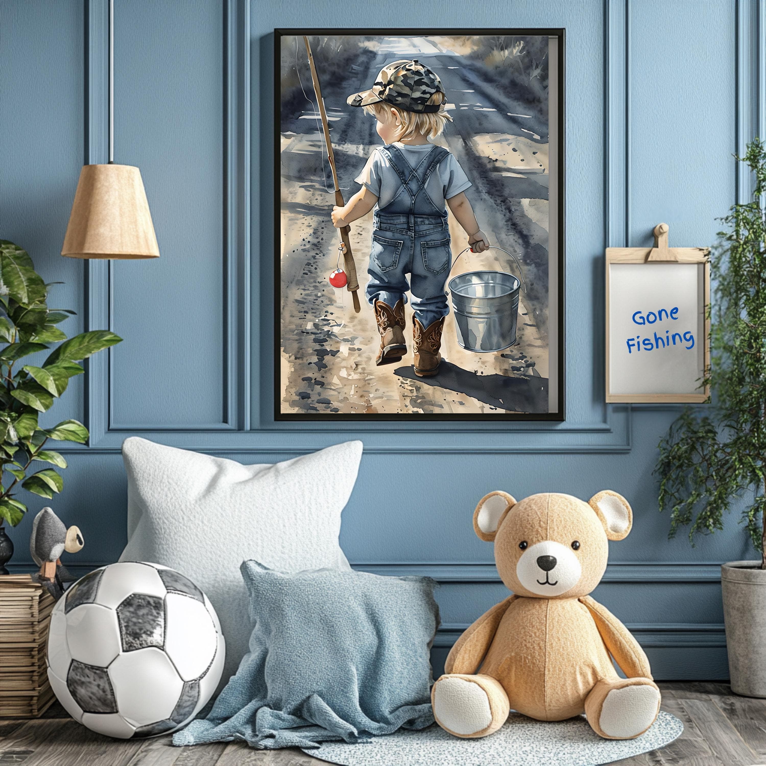 May include: A watercolor painting of a young child walking away from the viewer with a fishing rod and a bucket. The child is wearing a blue overall, a camouflage hat, and red shoes. The child is walking on a dirt path with green grass on either side. The painting is framed in a black frame and is hanging on a blue wall. A white sign with the text 'Gone Fishing' is on the wall to the right of the painting.