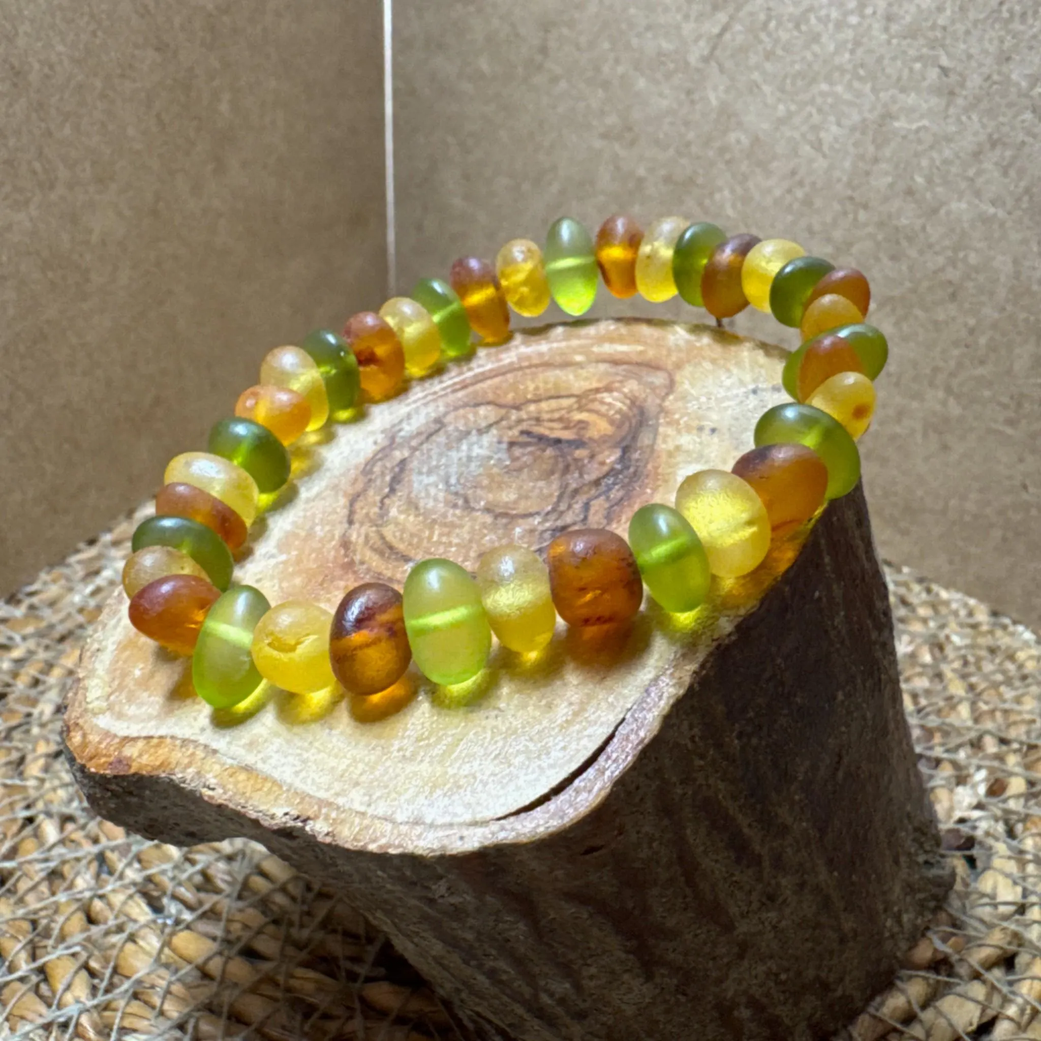 Unisex Baltic amber bracelet, natural polished beads in green and honey tones, handmade gemstone jewelry for everyday wear or gifting.