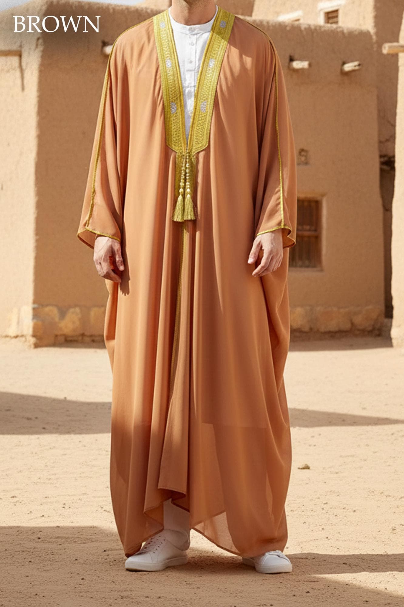 Man wearing a white sheer open-front Bisht robe with gold embroidery on the collar over a white thobe