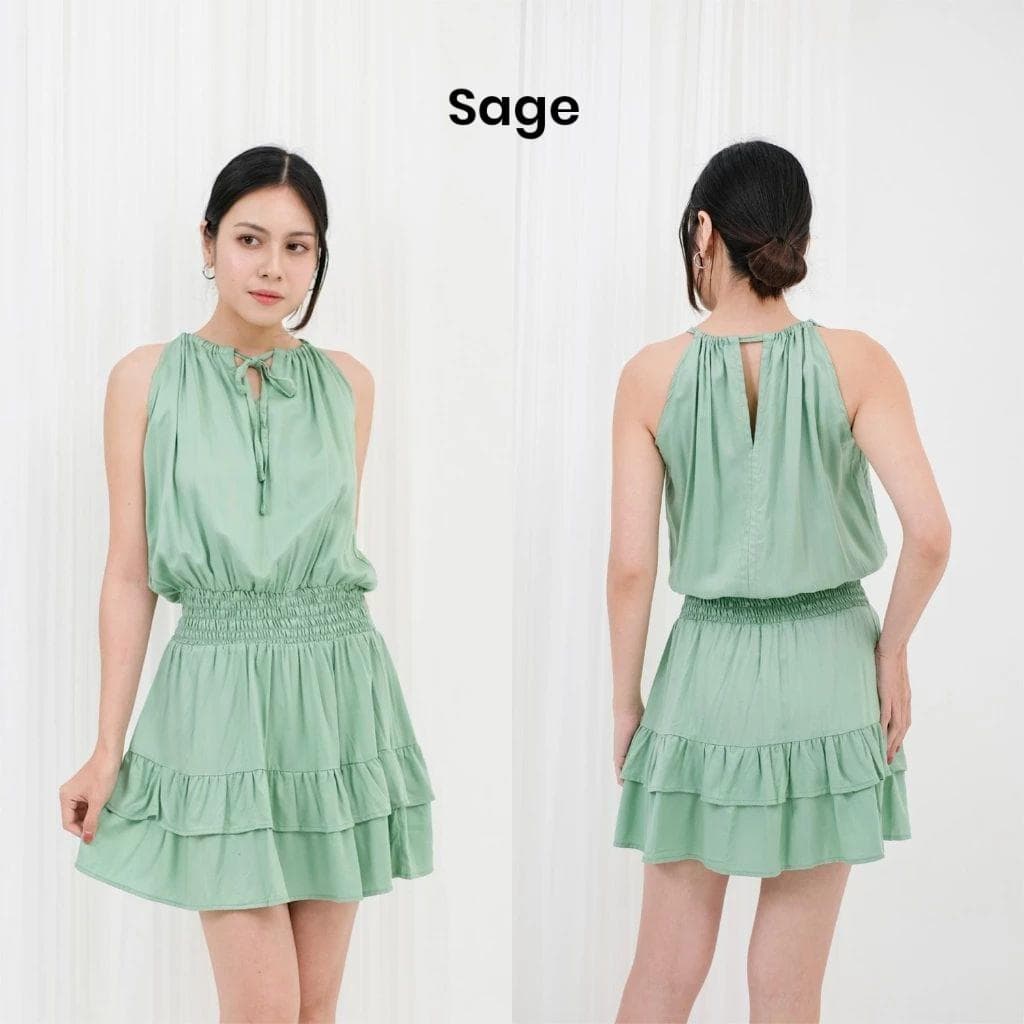 Floral rayon halter mini dress with elastic waist worn by a female model in a bright studio setting