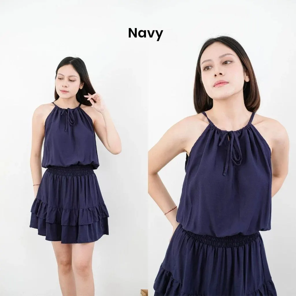 Floral rayon halter mini dress with elastic waist worn by a female model in a bright studio setting