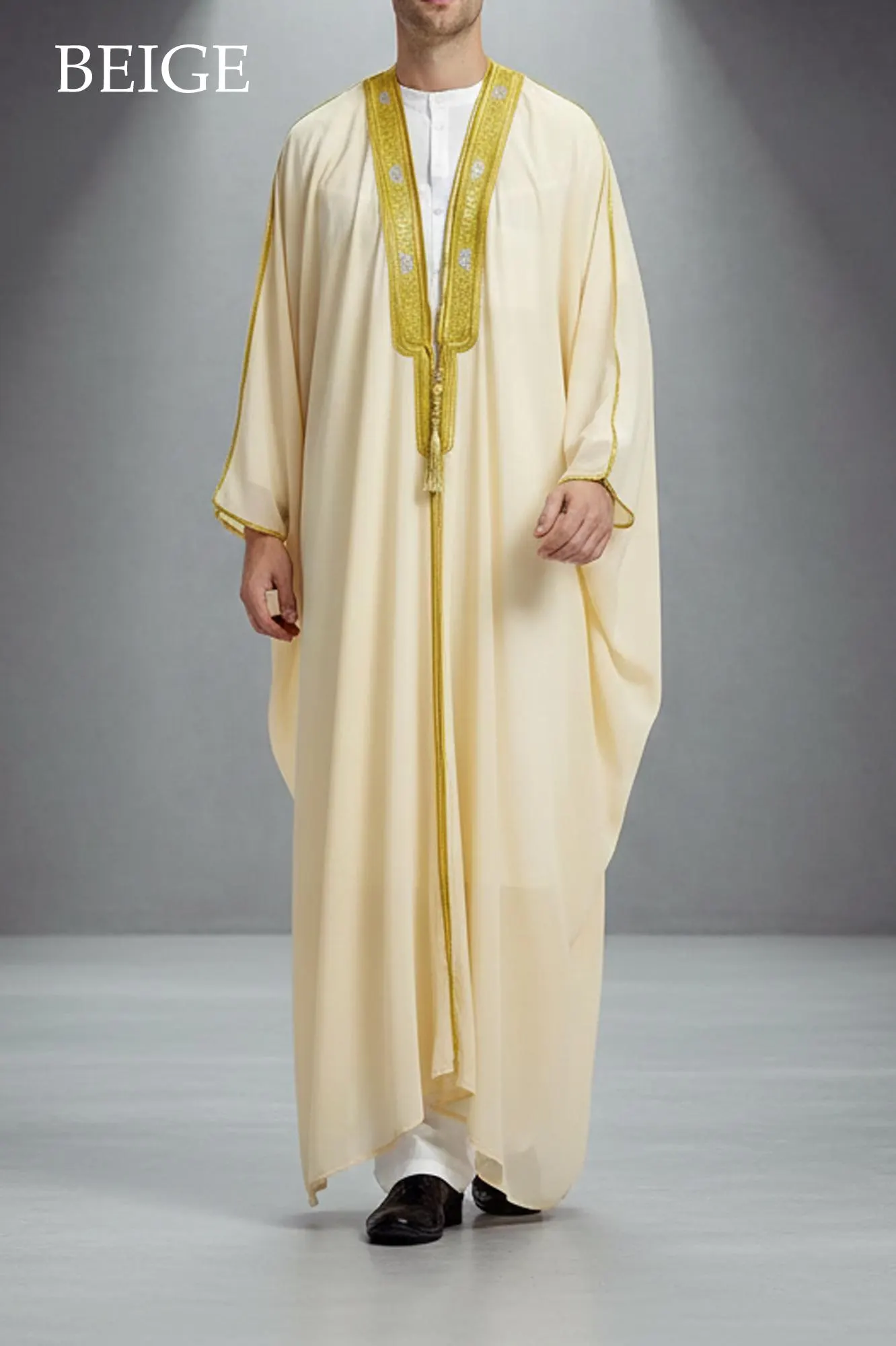 Man wearing a white sheer open-front Bisht robe with gold embroidery on the collar over a white thobe