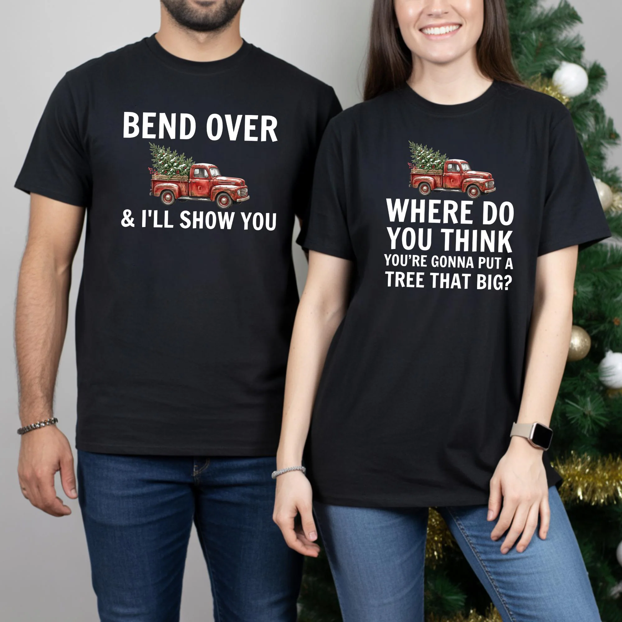A man and a woman are standing next to each other, both wearing black t-shirts with humorous text and graphics.