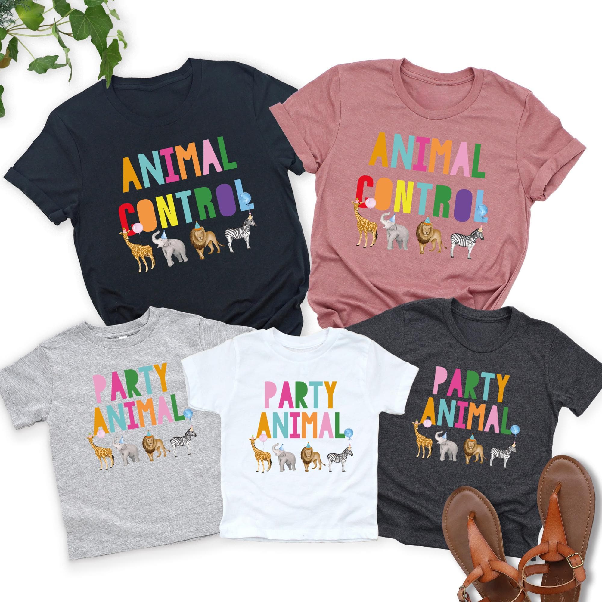 a collection of five t-shirts with the text "Animal Control" printed on them, featuring various animal illustrations. The t-shirts are arranged in a row, with the largest one being black, the second one being pink, the third one being gray, the fourth one being white, and the fifth one being black. There are also some sandals placed in the bottom right corner of the image.