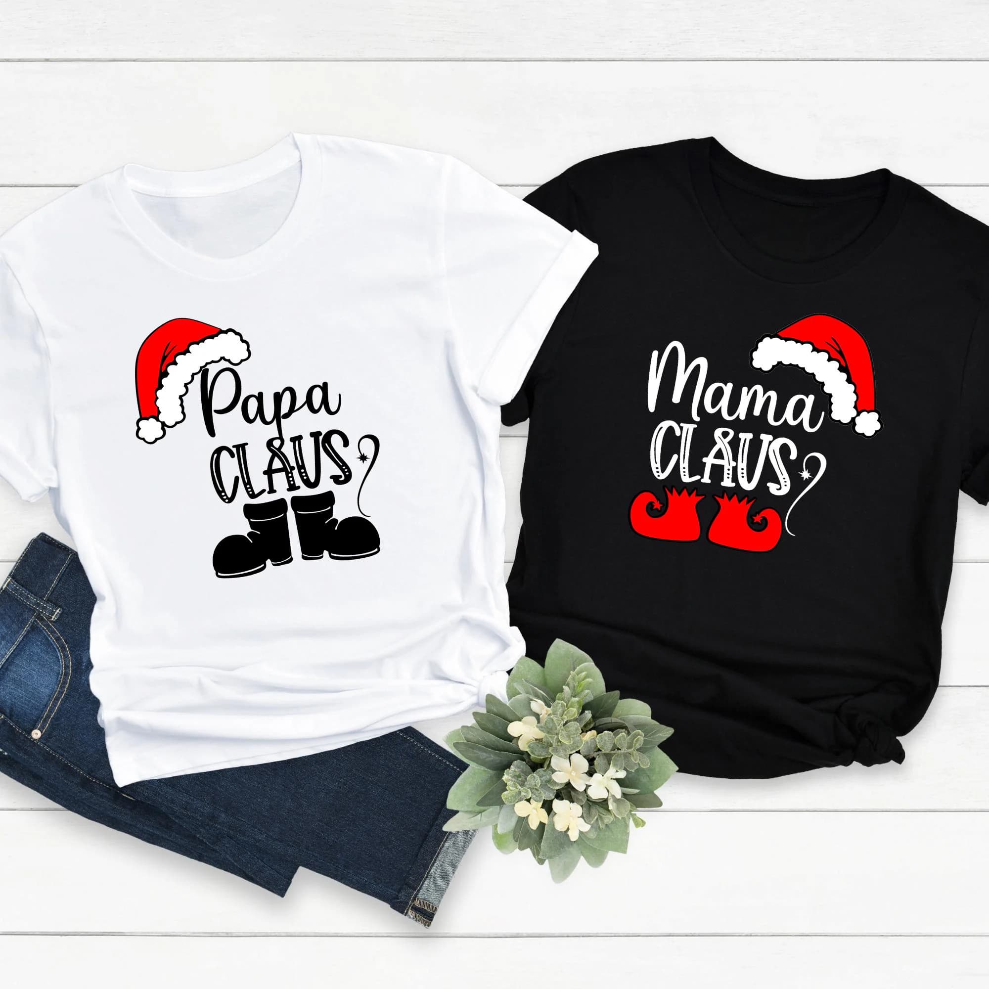 two t-shirts with Christmas-themed designs, one white and one black, along with a pair of jeans and a potted plant.